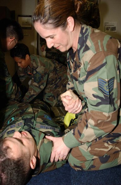 070313-F-0108B-007 MISAWA AB, JAPAN -- Tech. Sgt. Colleen Beverly comforts Senior Airman Raymond Bertram during a self-aid and buddy care scenario during phase one of base's Operational Readiness Inspection March 13, 2007.  The ORI is designed to make sure the Airmen are ready and able to respond to any combat scenario.(U.S. Air Force photo by Senior Airman Robert Barnett)