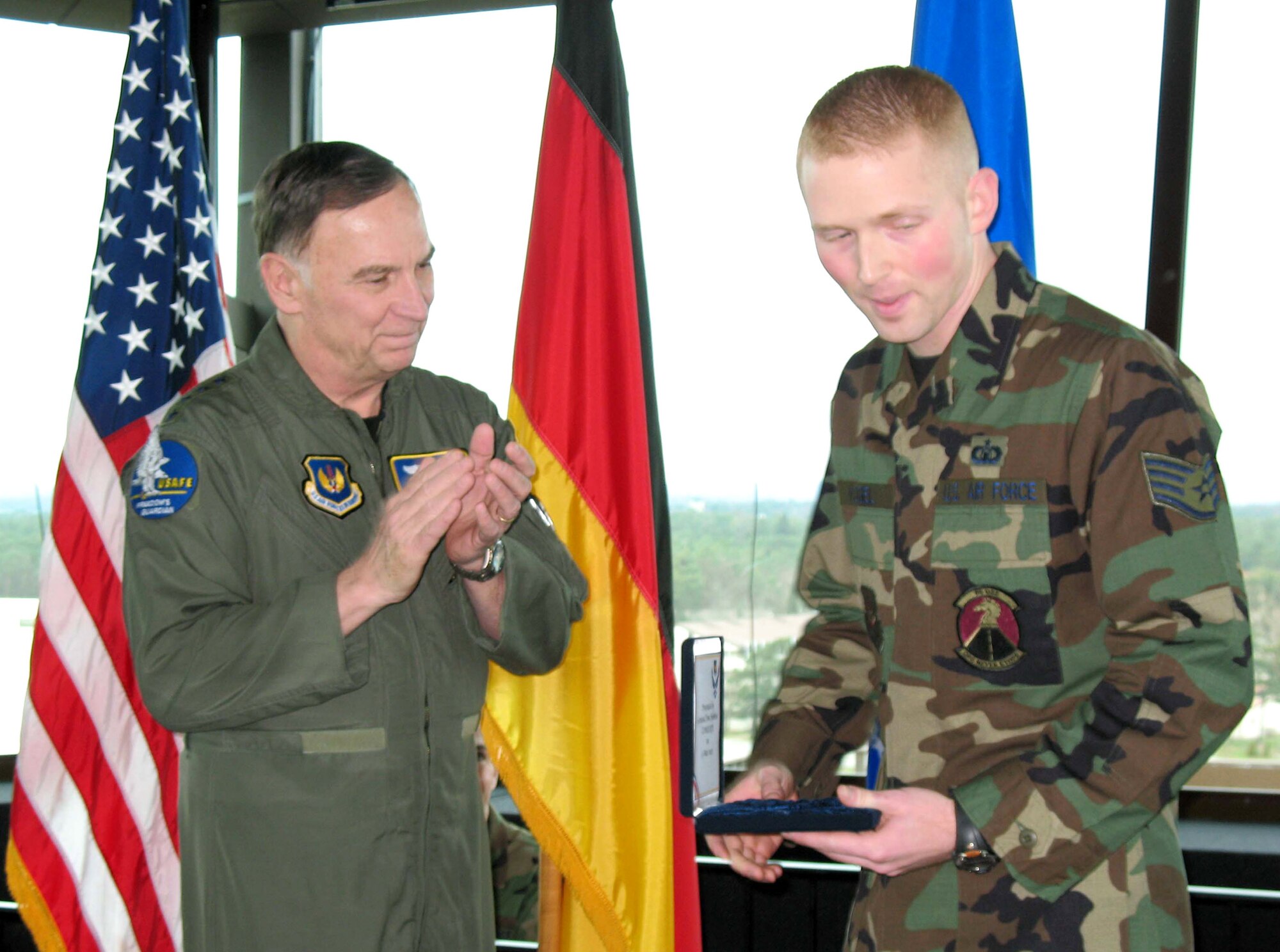 Gen. Tom Hobbins applauds Staff Sgt. Jess Vogel, control tower watch supervisor, who was one of three tower workers to be presented an Airman Committed to Excellence award. General Hobbins, the U.S. Air Forces in Europe commander, presented the awards March 13 during a ribbon-cutting ceremony for the new tower cab at Ramstein Air Base, Germany. (U.S. Air Force photo/Staff Sgt. Jason David)