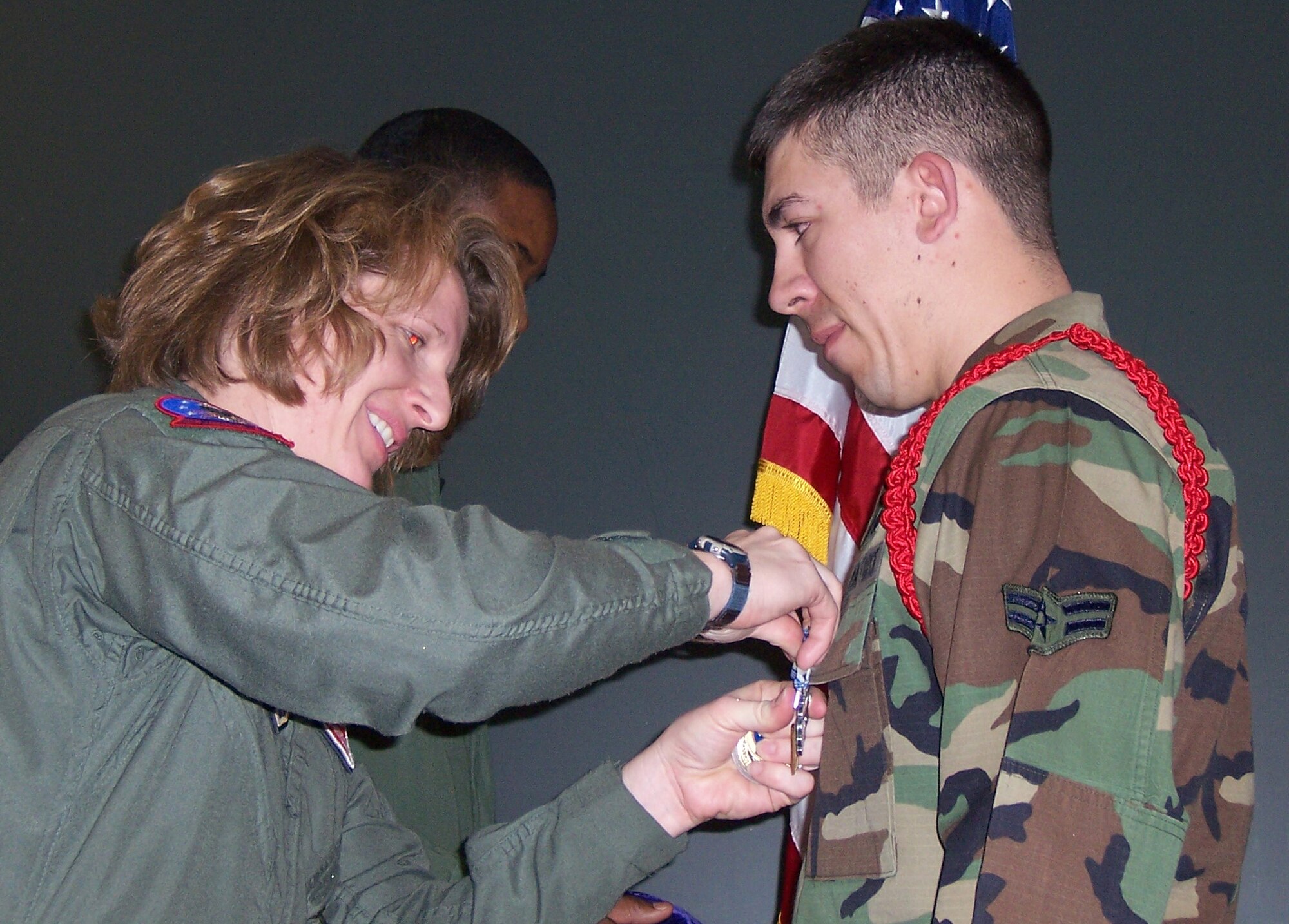 Lt. Col. Cathy Bartholomew, 97th Training Squadron commander, awards Airman 1st Class Adam K. Harrison, 97th Training Squadron C-5 loadmaster student, an Air Force Achievement Medal.