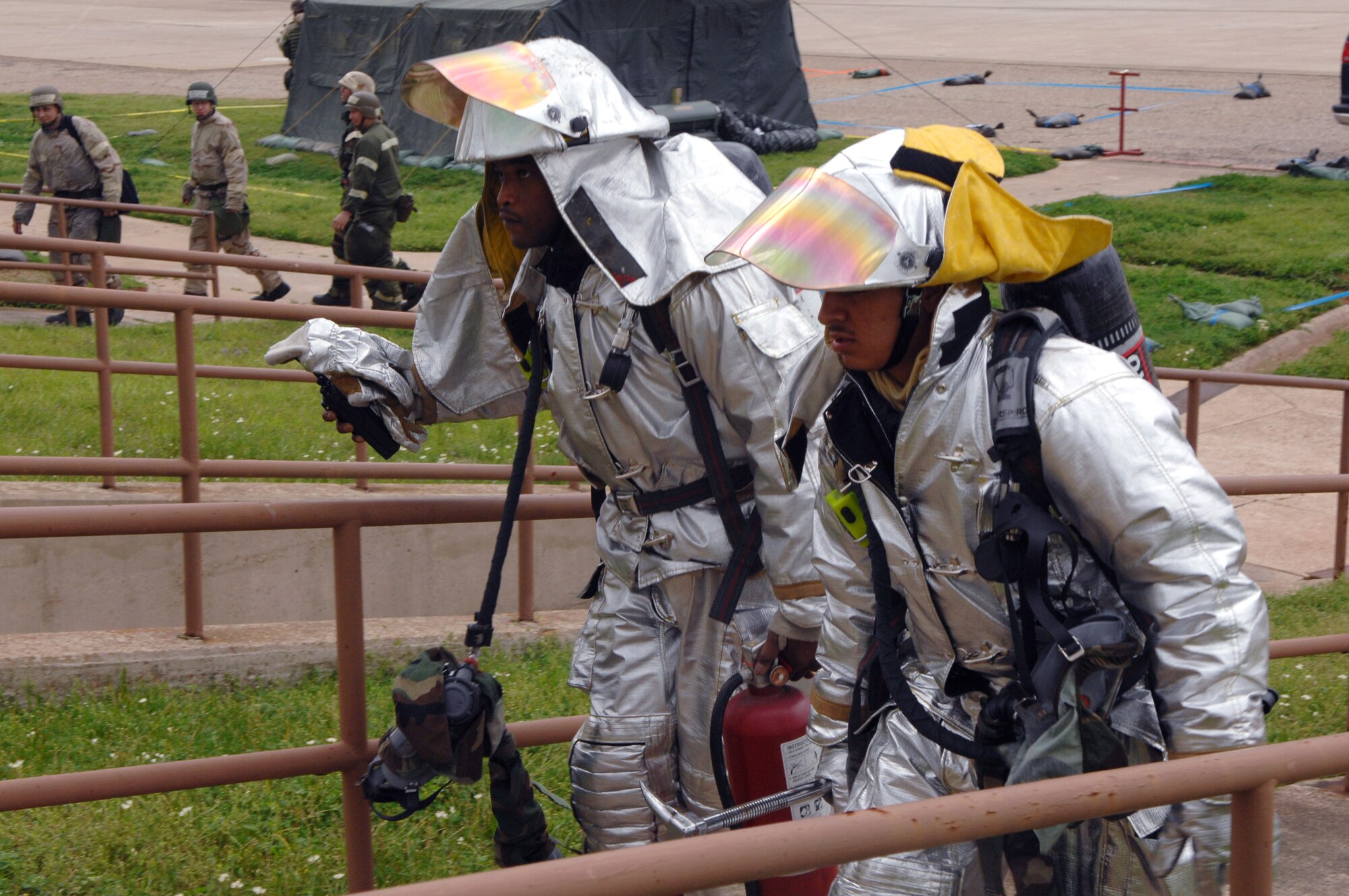 Staff Sergeant Roderick Wiggins (left) and Airman Michael Ramos rush to put out a mock electrical fire as part of a Conventional Operational Readiness Exercise March 12 at Barksdale Air Force Base, La. The Airmen are working in support of Global Cajun 07-2. (U.S. Air Force photo/Airman 1st Class Joanna Kresge)
