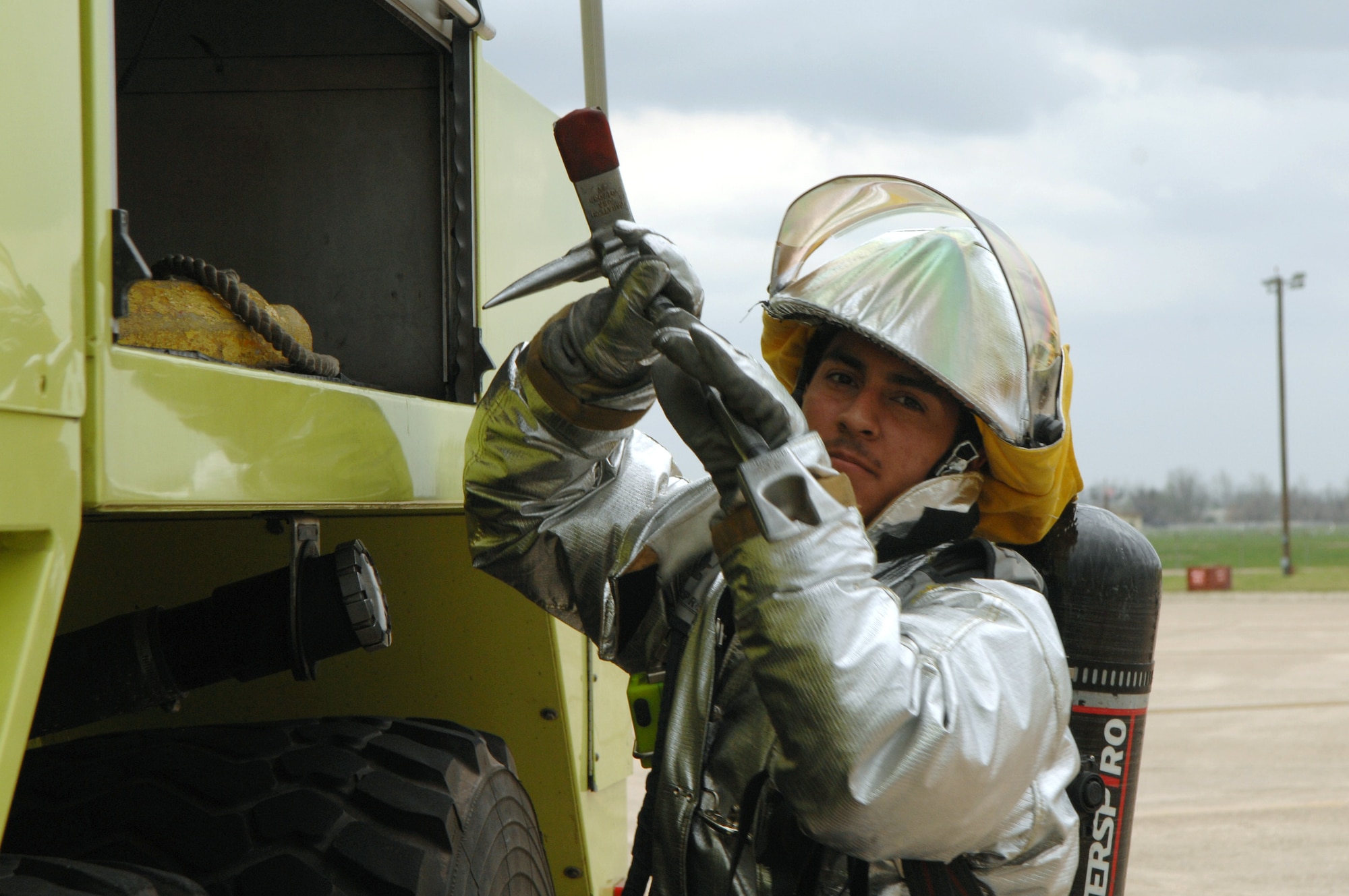 Airman Michael Ramos grabs a tool from a storage compartment on the outside of a fire truck Feb. 12 during a Conventional Operational Readiness Exercise at Barksdale Air Force, La. Airman Ramos is working in support of Global Cajun 07-2 exercise. (U.S. Air Force photo/Airman 1st Class Joanna Kresge)