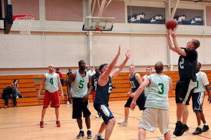 Kenneth Travis, 437th Aircraft Maintenance Squadron, shoots the ball as members of the 437th Services Squadron stand by for a rebound during the basketball game March 13 at the fitness center.  AMXS defeated SVS 58-31. (U.S. Air Force photo by Staff Sgt. Marie Cassetty)