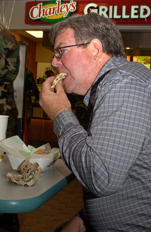 Retired Chief Master Sgt. Dallas Ratliff enjoys a Charley's grilled sandwich at the grand opening of the new Base Exchange food concessionaire March 5. (U.S. Air Force photo/Tech. Sgt. Paul Kilgallon)