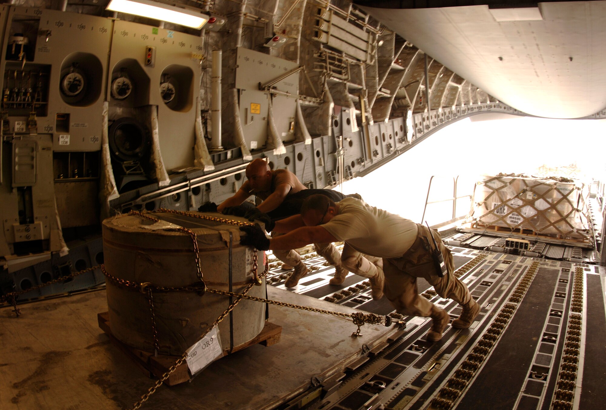 Aerial porters from the 8th Expeditionary Air Mobility Squadron load palletized cargo onto a C-17 Globemaster III for intratheater shipment. The cargo sits on rollers on the ramp and is pushed into the plane by a 60K loader. The squadron processes about 250,000 pounds of cargo for intertheater and intratheater shipments each day. (U.S. Air Force photo/Staff Sgt. David Miller) 