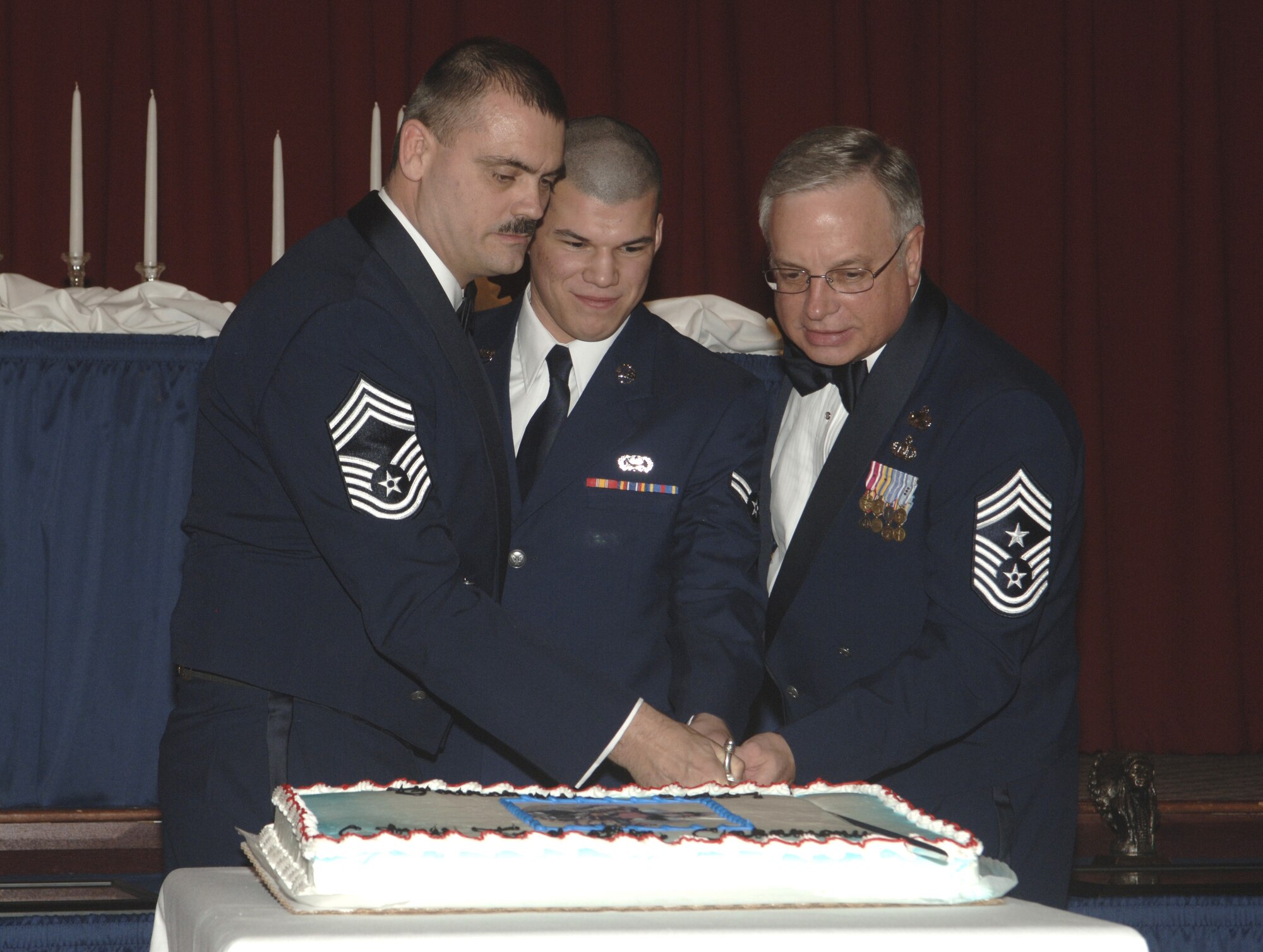 FAIRCHILD AIR FORCE BASE, Wash. -- Chief Master Sgt. Jon Stuhr, 66th Training Squadron, Airman 1st Class Luis Arteaga, 92nd Services Squadron, and Chief Master Sgt. Craig Weddle, 141st Air Refueling Wing command chief, cut the cake. (U.S. Air Force photo/Senior Airman Chad Watkins)
