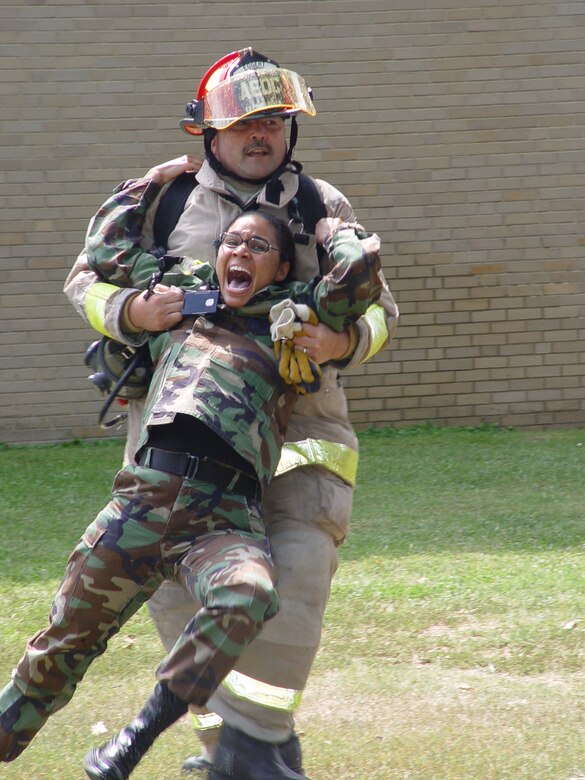AEDC firefighter and crew chief Dennis Eggert had his hands full as he assisted Tech.
Sgt. Naomi Bullock, who portrayed a panicked ‘survivor’ of a simulated terrorist attack during an emergency response drill Sept. 15, 2006. The training exercise was held in response to a simulated scenario in which a small plane carrying explosives was fl own into the center’s headquarters building. (photo by Philip Lorenz III)