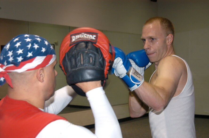 Jeff Langham, a former B-1 crew chief, practices a power punch with Corando Flores, Jr., during a cardio kickboxing class March 13. "Junior" Flores is a national kickboxing champion who conducts classes at the fitness center here Tuesdays and Thursdays at 7 p.m. (U.S. Air Force photo by Airman 1st Class Carolyn Viss)