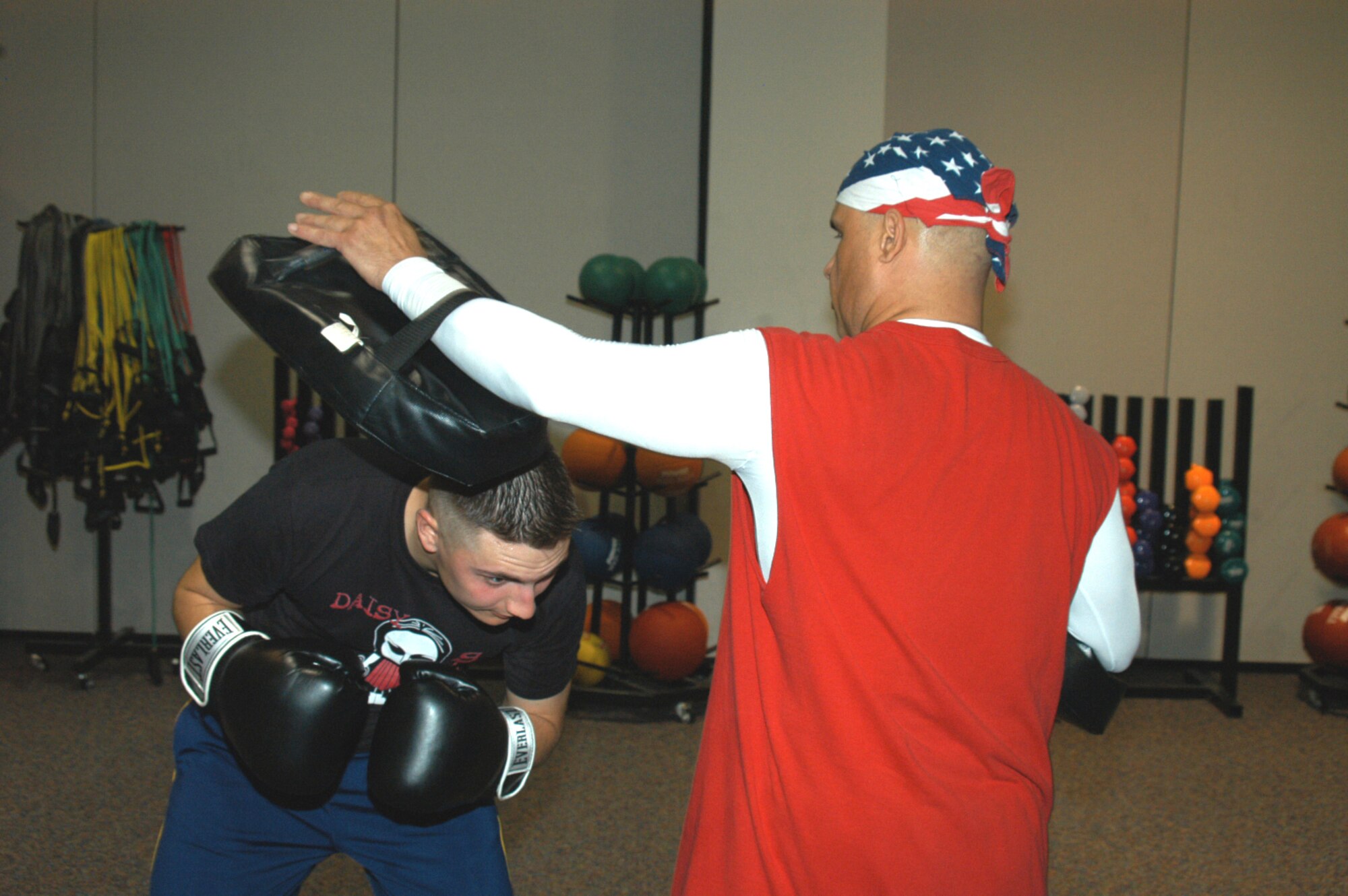 Airman 1st Class Richard Armstrong, 7th Comptroller Squadron, dodges a straight punch from cardio kickboxing instructor Corando Flores, Jr., at the fitness center March 13. Classes are offered Tuesdays and Thursdays at 7 p.m. (U.S. Air Force photo by Airman 1st Class Carolyn Viss)                               