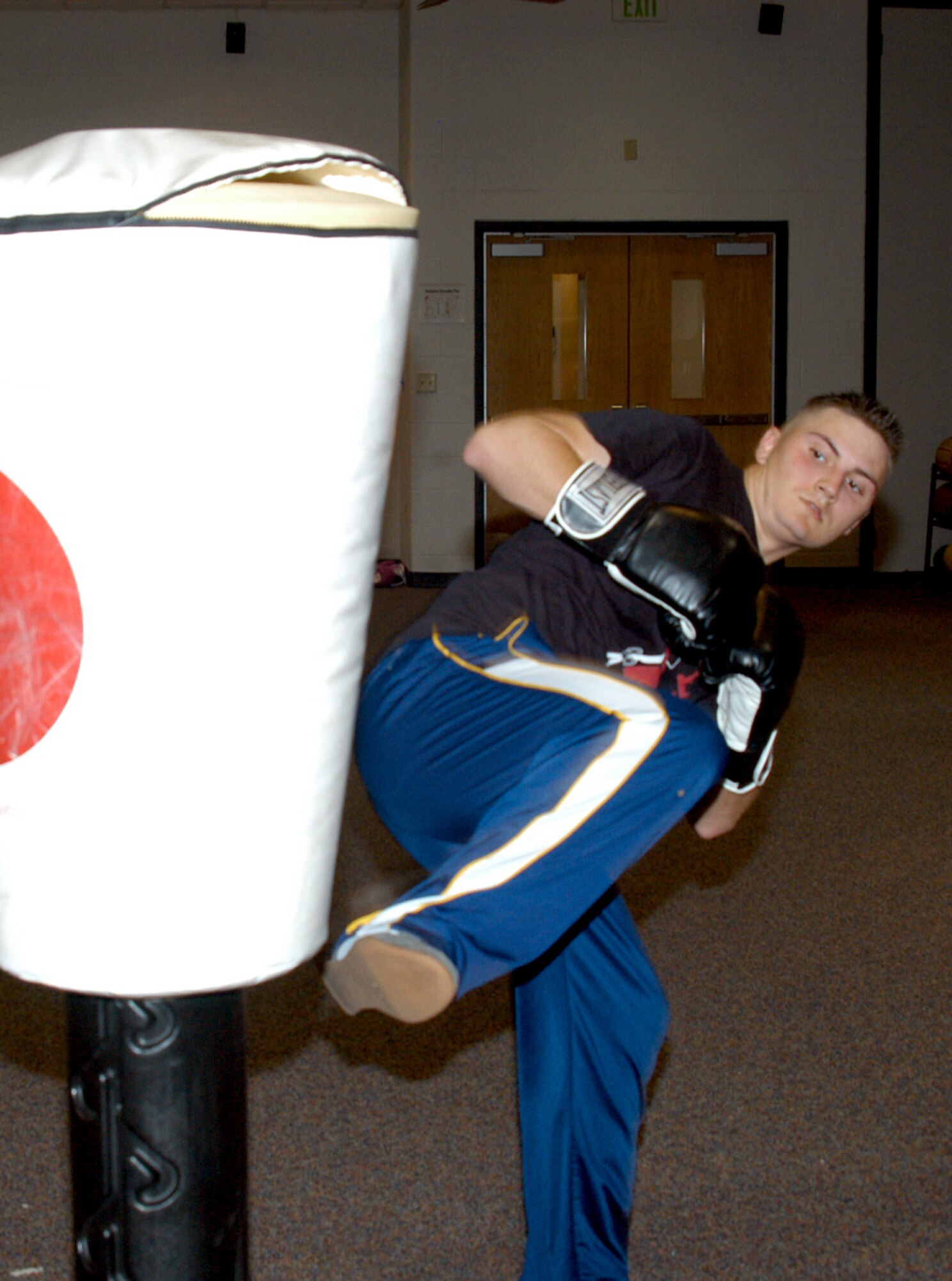 Airman 1st Class Richard Armstrong, 7th Comptroller Squadron, throws a side kick to a punching bag during cardio kickboxing at the fitness center March 13. The class, taught by Corando Flores, Jr., national kickboxing champion, offers instruction in strength, cardio, balance and control of body movement. (U.S. Air Force photo by Airman 1st Class Carolyn Viss)