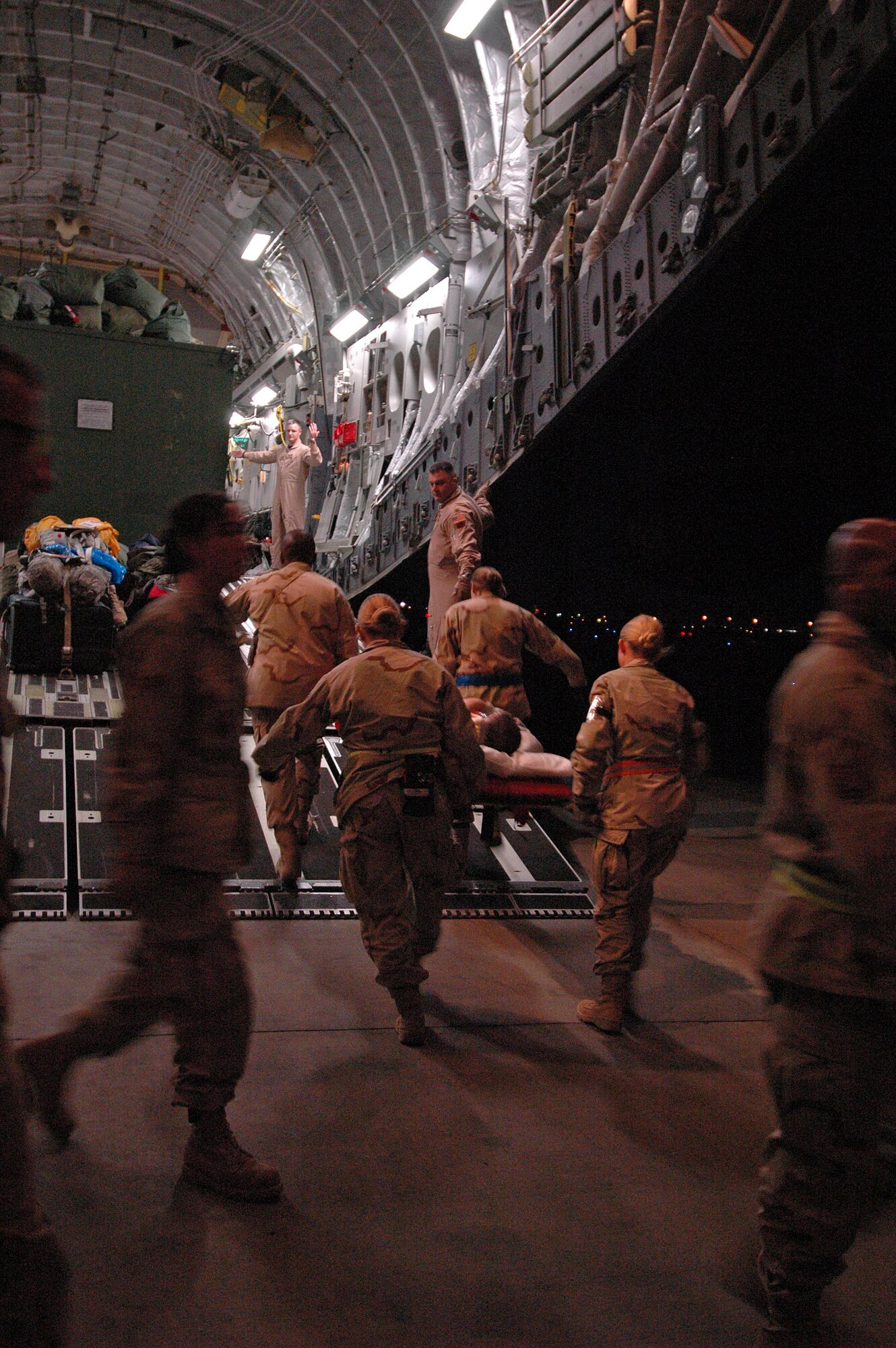 Air Force aeromedical evacuation team members load a patient onto a Mississippi Air National Guard C-17 Globemaster III at Balad Air Base, Iraq, on March 3 during a scheduled flight to Ramstein Air Base, Germany. (U.S. Air Force photo/Tech. Sgt. Mike Smith) 
