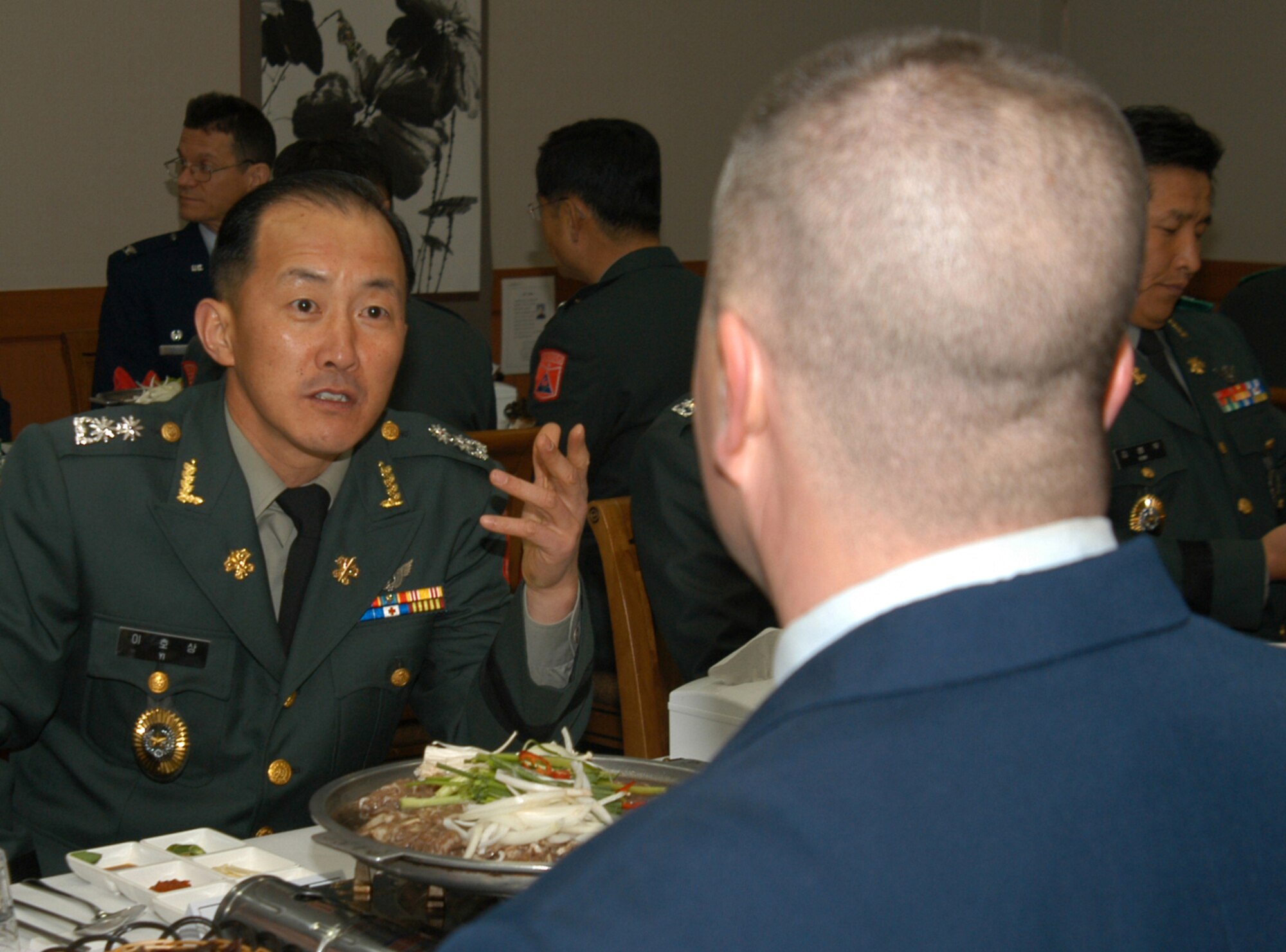KUNSAN AIR BASE, Republic of Korea March 10, 2007 -- A Republic of Korea lieutenant colonel converses with Master Sgt. Chambliss McKendree about martial arts March 10. Members of the 8th Fighter Wing got to better know the ROK officers and senior enlisted members over a serving of bulgogi, rice and soup. Sgt. McKendree is assigned to the 8th Aircraft Maintenance Squadron. (Air Force photo/Senior Airman Stephen Collier)                                                                                            