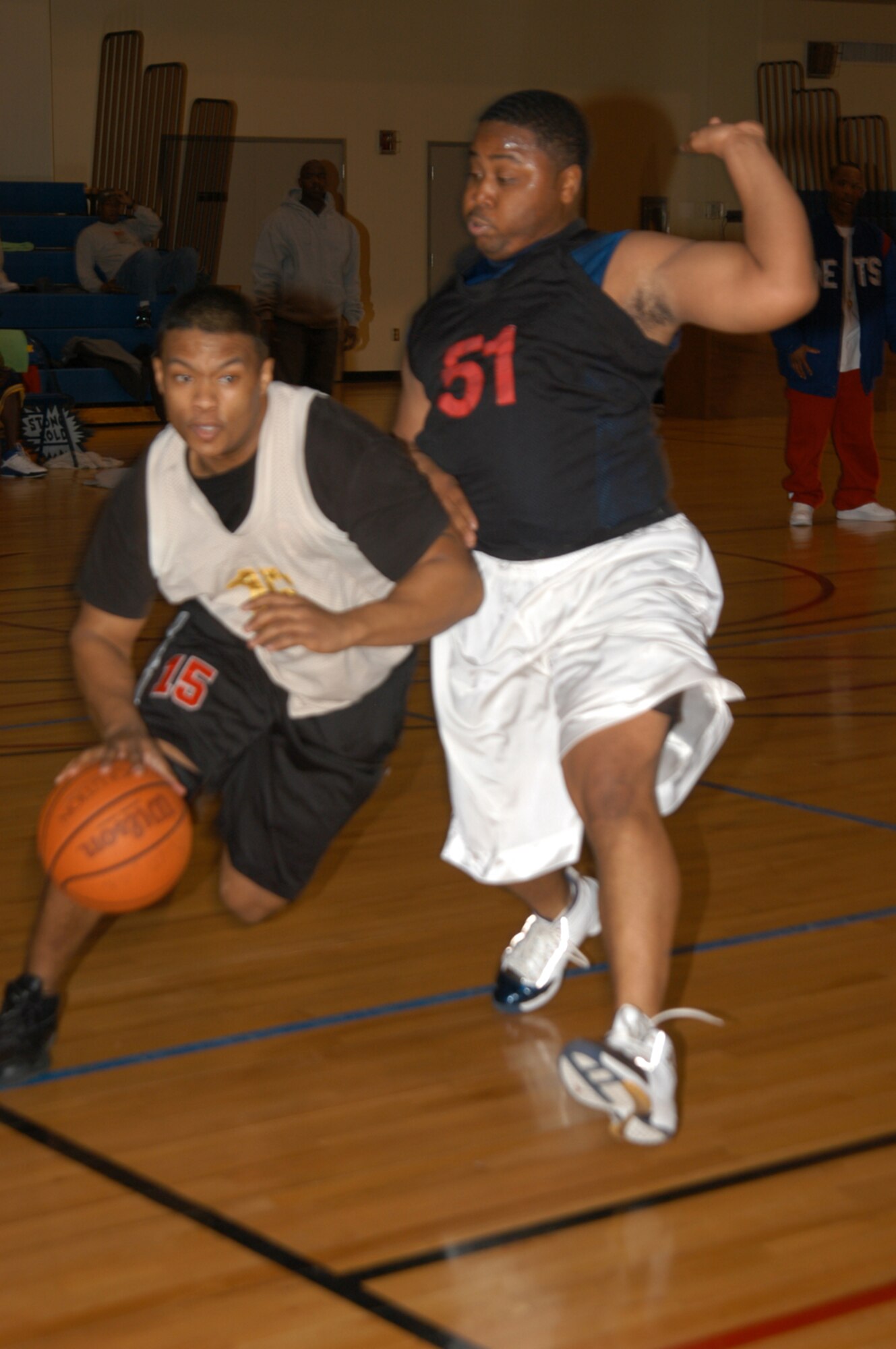 KUNSAN AIR BASE, Republic of Korea March 9, 2007 -- A Red Devil forward forces his way past Cobra defender Brian Racy March 9 during the 2006-2007 intramural basketball championship game. The Red Devils, or 8th Civil Engineer Squadron, lead the entire game against the 8th Aircraft Maintenance Squadron 'Cobras,' but lost at the last minute from a game-winning three pointer. (Air Force photo/Senior Airman Stephen Collier)                          