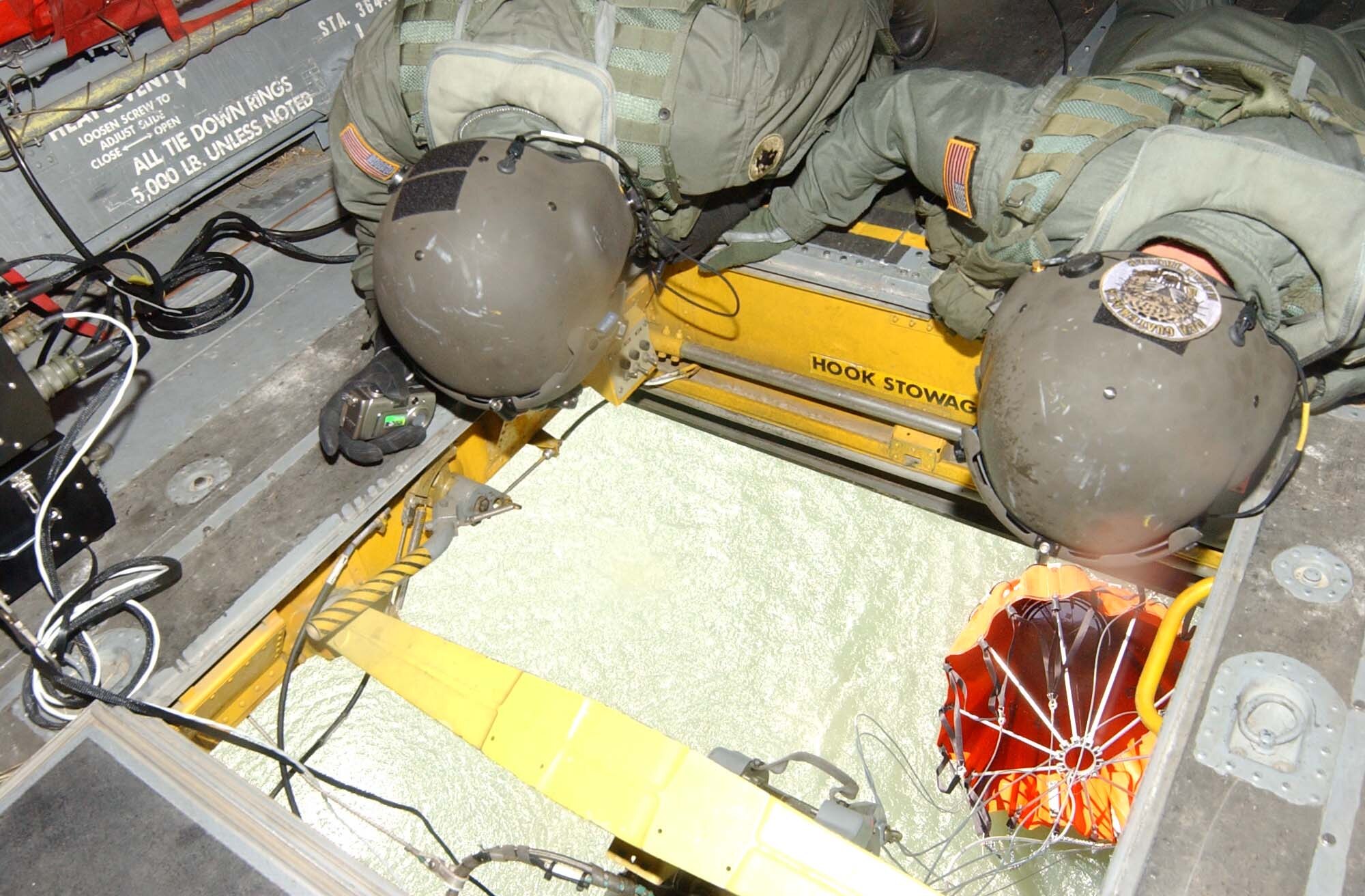 Army Staff Sgt. Michael Wagner, left, and Army Sgt. Chris Salmond, both with Bravo Company, 1st Battalion, 228th Aviation Regiment, check the position of a "Bambi Bucket" under their CH-47 Chinook helicopter during a training mission March 15.  The 2,000-gallon bucket is designed to hang from the helicopter, collect water, and disperse the water at the touch of a button over a fire.  The training took place in small body of water along the Rio del Hombre, near the town of Zambrano, Honduras. (U.S. Air Force photo/Tech. Sgt. Sonny Cohrs)