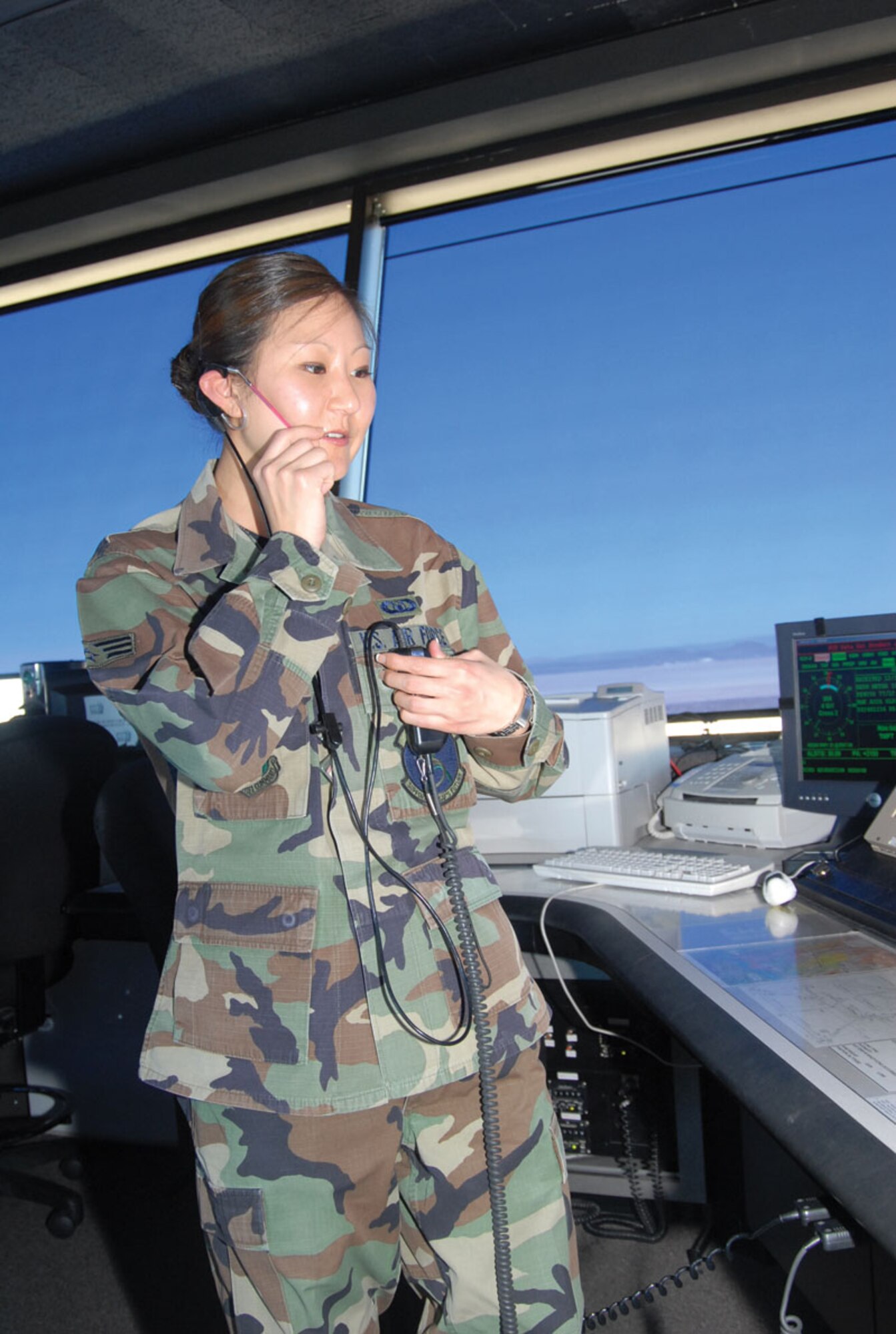 Senior Airman Christine Kim, an air traffic controller with the 412th Operations Support Squadron, talks to a pilot on the radio here. (Photo by Senior Airman Jason Hernandez)