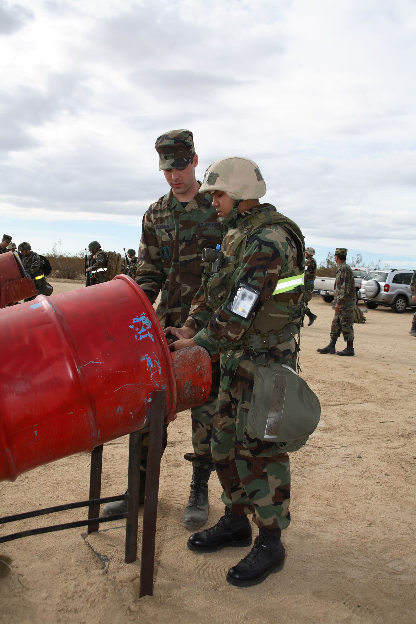 First Lt. Jason Hileman, 411th Flight Test Squadron, helps 2nd Lt. Steve Lanuzo, 771st Test Squadron, with M9 pistol clearing procedures. During Phase II, Airmen were evaluated in self aid and buddy care, unexploded ordnance sweeps and weapons disassembly as well as camp fortification and maintenance. (Photo by Jet Fabara)