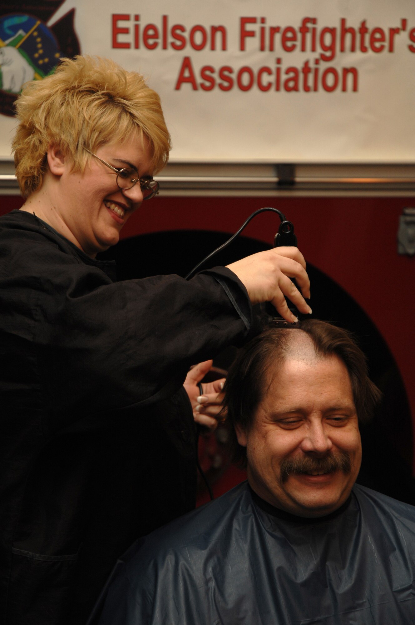 EIELSON AIR FORCE BASE, Alaska -- After proclaiming "For the Children!" Mr. Peter Matheis, 354th Civil Engineer Squadron fire fighter station chief, gets his head shaved on March 15 at Fire Station #1 by Mrs. Sammantha Tippets, wife of fire fighter Staff Sgt. Stephen Tippets. Members of the Eielson Fire Fighter Association shaved their heads to raise money for St. Baldricks Foundation which raises funds for childrens cancer research.
(U.S. Air Force Photo by Staff Sgt Joshua Strang)