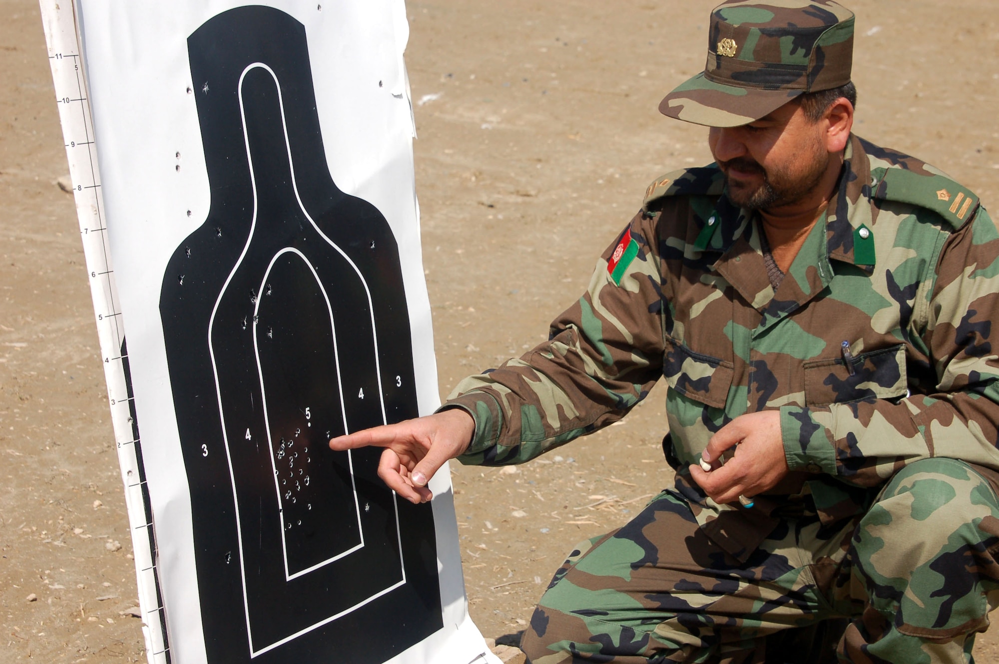 Afghan National Army Capt. Abdul Rahman inspects his target March 14 after firing an M-16 at a shooting range at the Kabul Military Training Center. Captain Rahman, the 1st Company military police commander, has been in the ANA since its inception in 2002.  (U.S. Air Force photo/Senior Airman Stacia Zachary)