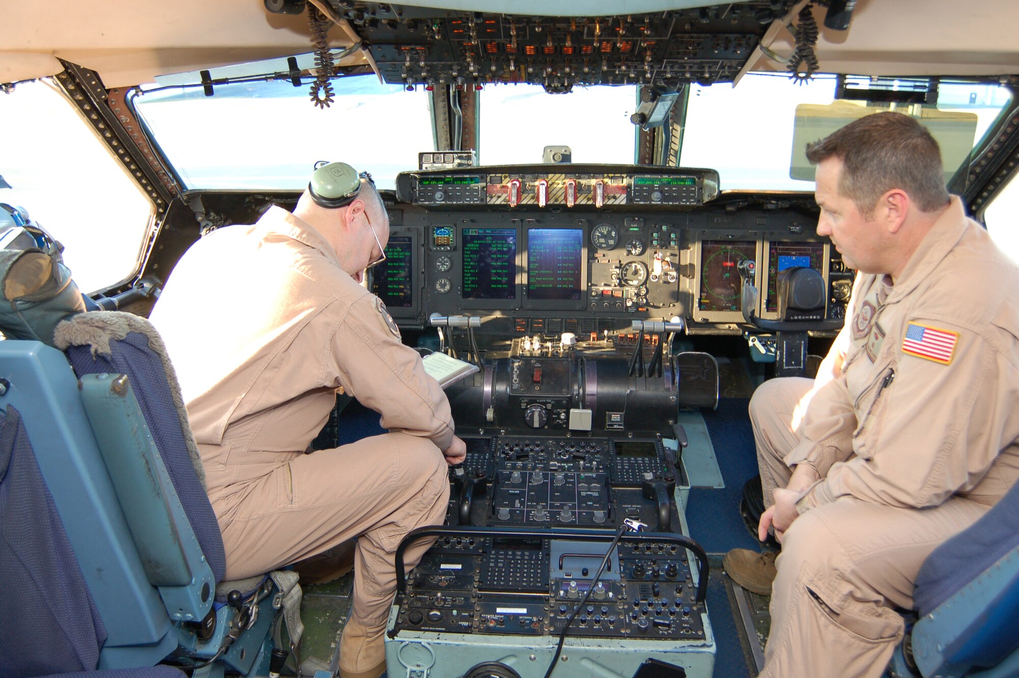 (Left to right) Master Sgt. Terence Miller carries out actions on a C-5 flight engineer checklist while Tech. Sgt. Mike Fischer oversees the recurring evaluation before takeoff of the 3rd Airlift Squadron's final C-5 mission March 4.