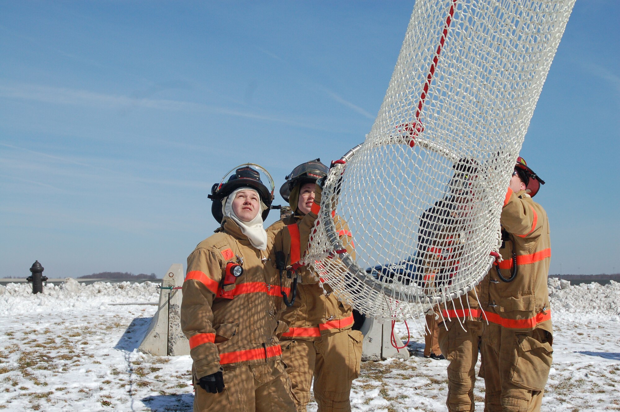 (Left to right) 436th CES firefighters Airman Herron, Airman Blessing, Mr. McCombs and Mr. Peers wait to remove tower controllers from the life chute, which was installed on the tower's catwalk and is designed to safely assist controllers to the ground level in the event of an emergency. (U.S. Air Force photo by Tech. Sgt. Kevin Wallace)