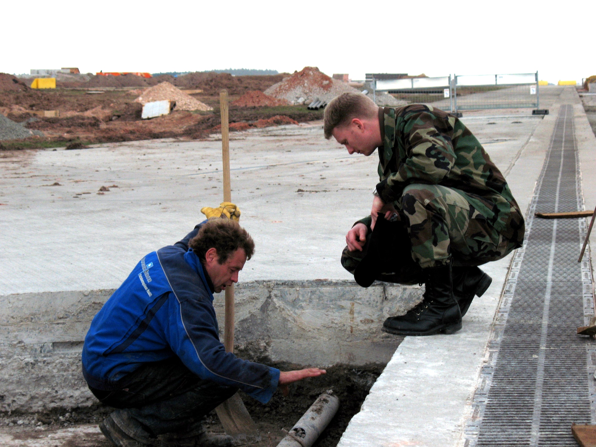 Capt. David Vanderburg, chief of construction management, inspects the work the local German contractors making repairs to a 50-year-old runway March 9 at Ramstein Air Base, Germany. Once complete, Ramstein will have two operational runways able to handle the biggest cargo planes in the Air Force inventory. (U.S. Air Force photo/Tech. Sgt. John Somheil)