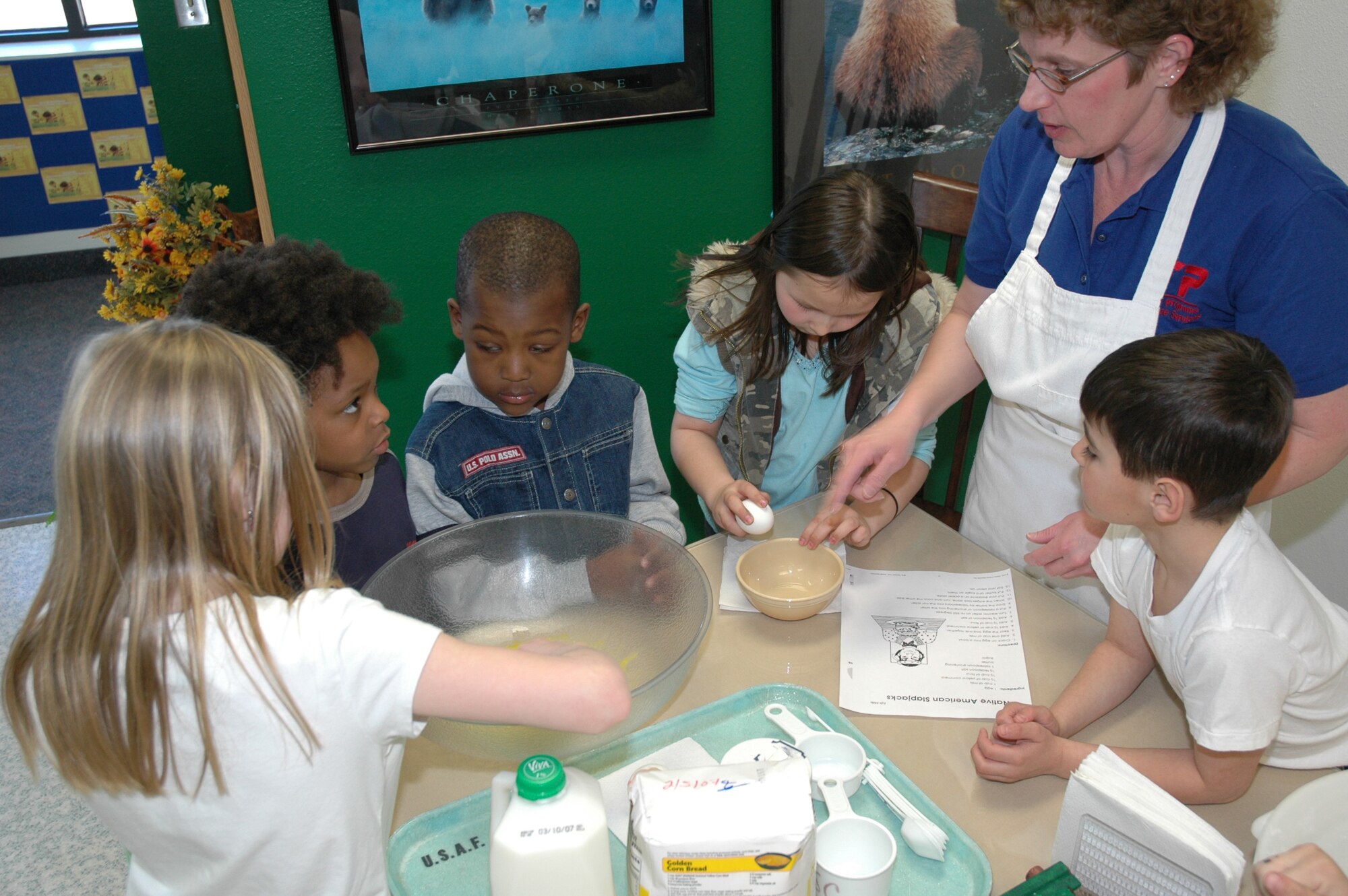 Little Warriors take turns adding and combining the ingredients for Native American Slapjacks during 4-H cooking class March 7 at the Youth Center.