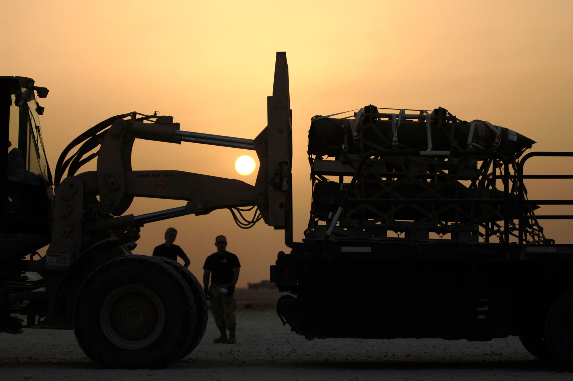 Aerial porters load pallets of bombs onto an aircraft loader in preparation for a night load. Approximately 2.1 million pounds of cargo are loaded per week in Southwest Asia.  The aerial porter's current mission supports Operation Achilles, a campaign to create a secure environment and better quality of life for Afghan citizens.  The Airmen are assigned to the 8th Expeditionary Air Mobility Squadron. (U.S. Air Force photo/Tech. Sgt. Cecilio Ricardo Jr.)