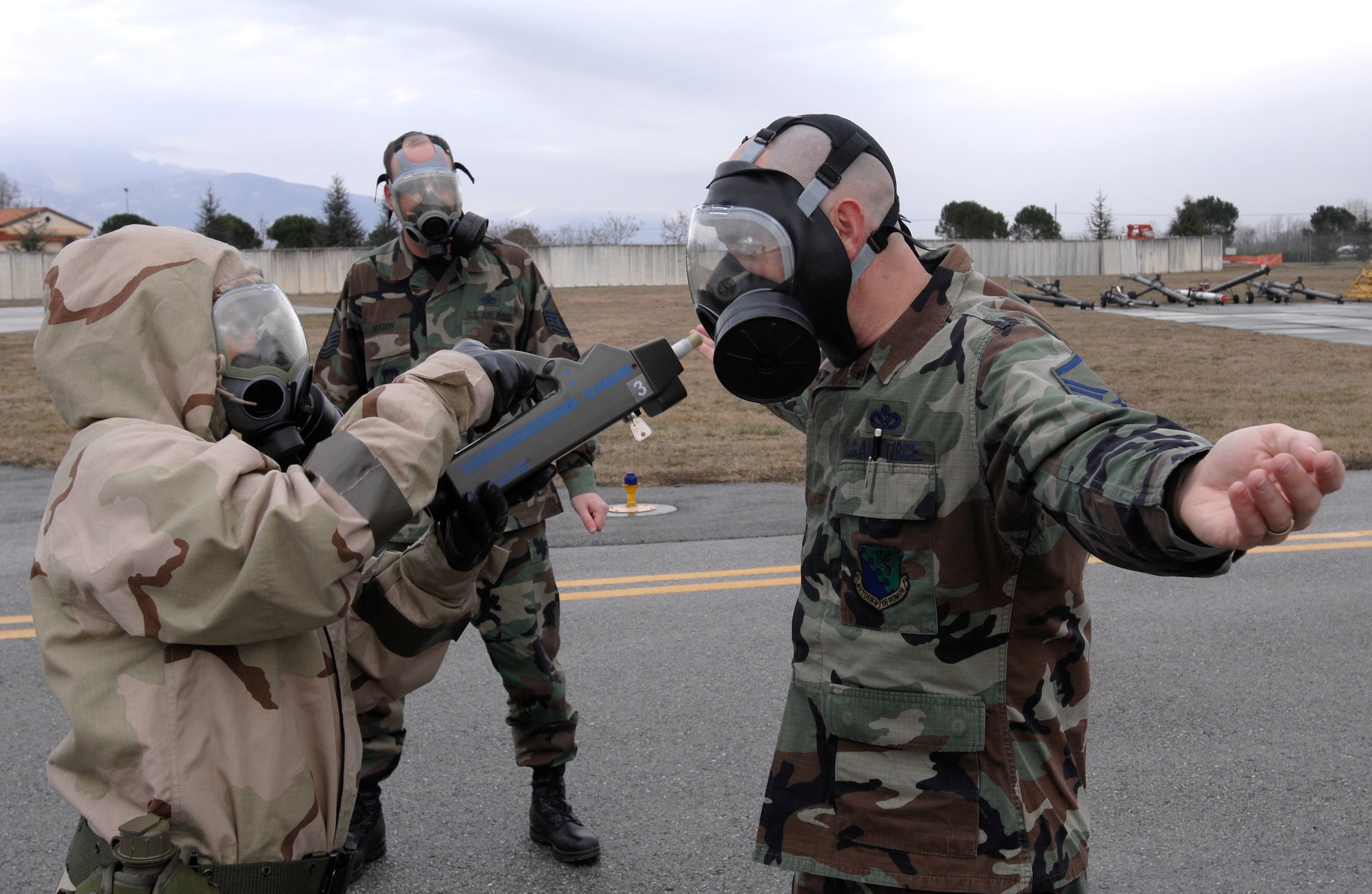Master Sgt. Gerald Bloss, 31st Civil Engineer Squadron, right, goes through the mask monitoring and removal section of a decontamination line March 6.  (U.S. Air Force photo by Airman 1st Class  Liliana Moreno)