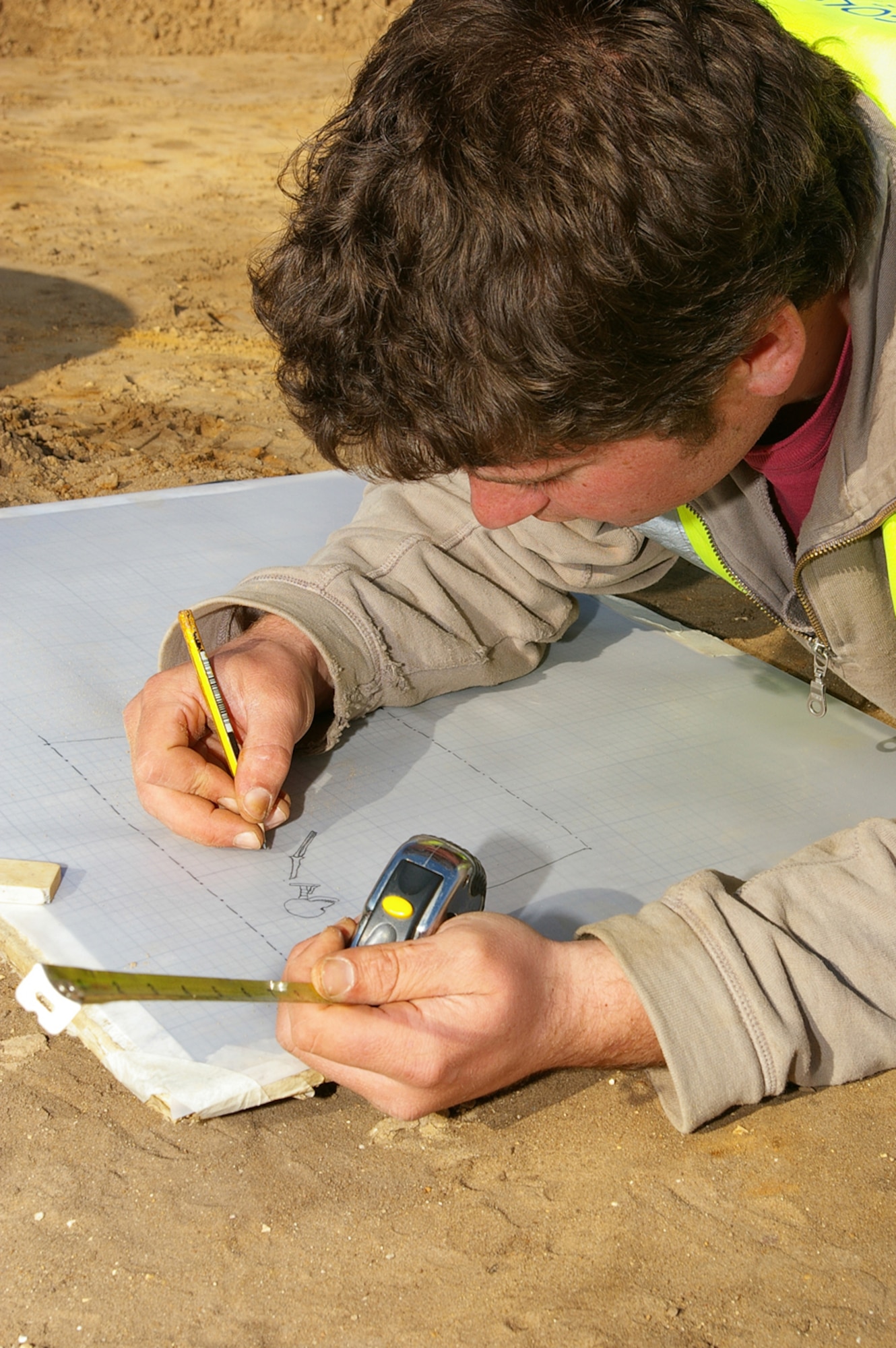 John Sims, Suffolk County Council archeological service, draws a sketch of the human skeleton he discovered March 12 during an archeological dig at the RAF Mildenhall officers' housing area in Beck Row. The skeleton was completely uncovered March 14. It is thought to be up to 2,000 years old. The skeleton has now been removed from the area and will be studied by archeology specialists to uncover further details about it. (U.S. Air Force photo by Karen Abeyasekere)