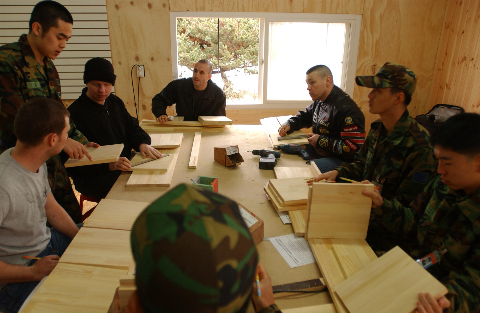 OSAN AIR BASE, Republic of Korea --  Senior Airman Kim, Jun-Yong, Republic of Korea Air Force public affairs office, helps members from the 51st Fighter Wing and 7th Air Force with a wood working project Saturday. The group went to the Wootdali Cultural Center near Osan at the invitation of the ROK Air Force Operations Command as part of the Good Neighbor Program. (U.S. Air Force photo by Airman Jason Epley)