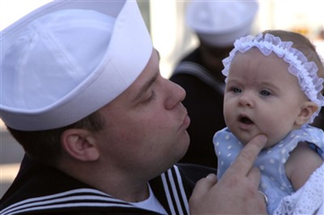 U.S. Navy Petty Officer 3rd Class Rick Pfeifer embraces his 3-month old daughter for the first time at the homecoming ceremony for guided missile cruiser USS Bunker Hill in San Diego, March 13, 2007. 
