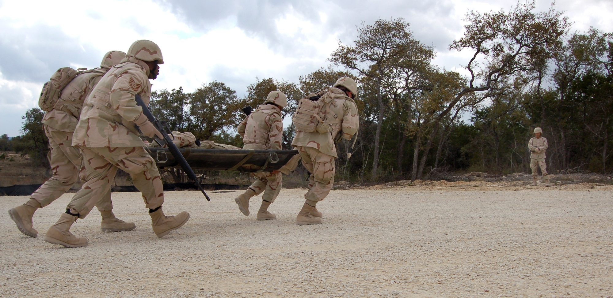 Students at the specialized mission course carry a simulated injured Airmen during combat convoy training at Camp Bullis, Texas. The two week course is the students first step in a mission that will help the Iraqi air force rebuild their technical schools. (U.S. Air Force photo/Airman 1st Class Robbie Arp)
