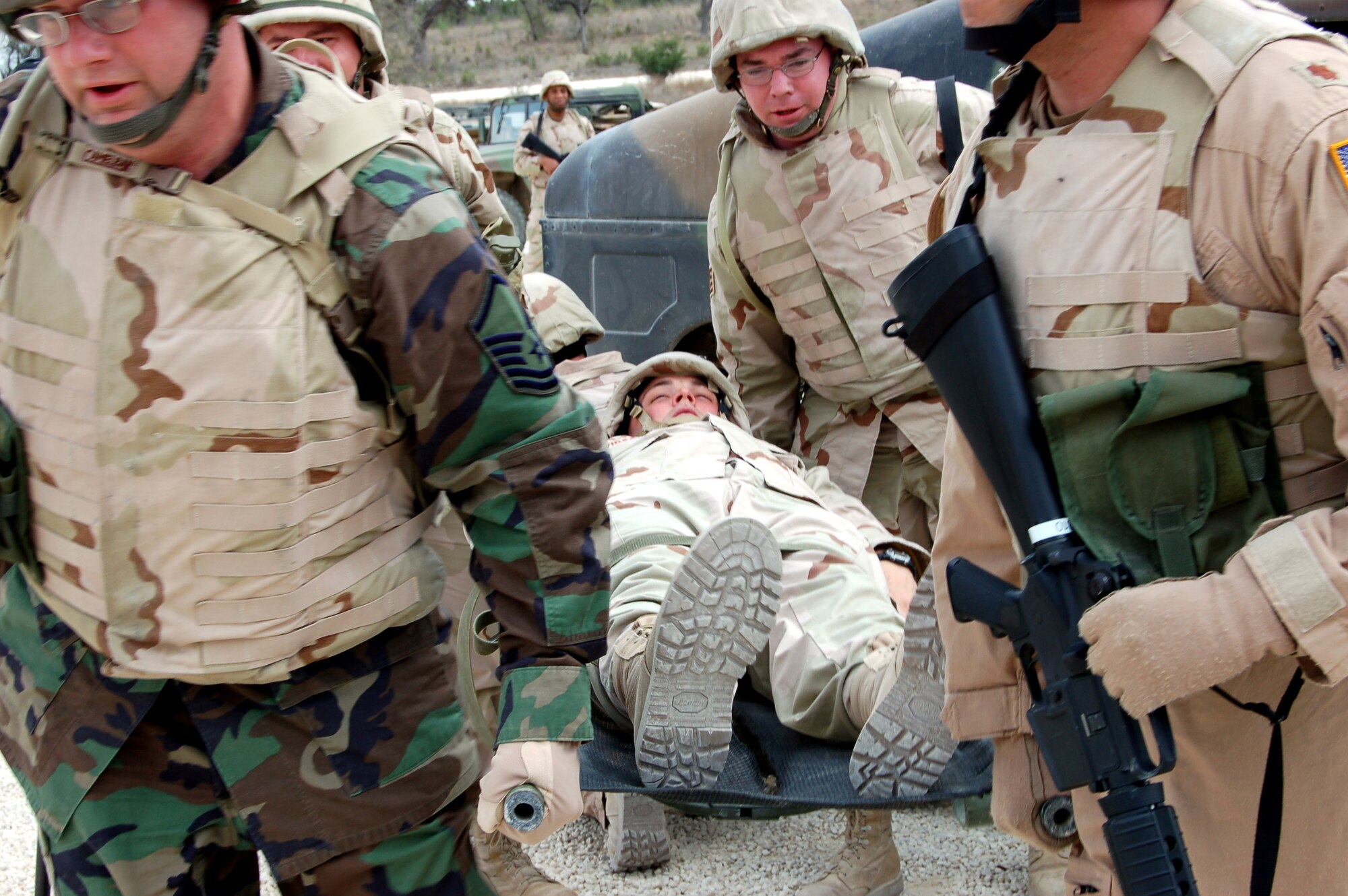 Students at the specialized mission course lift Tech. Sgt. Randy Davidson during a simulated convoy operation held at Camp Bullis, Texas. The two week course is the students first step in a mission that will help the Iraqi air force rebuild their technical schools. (U.S. Air Force photo/ Airman 1st Class Robbie Arp)