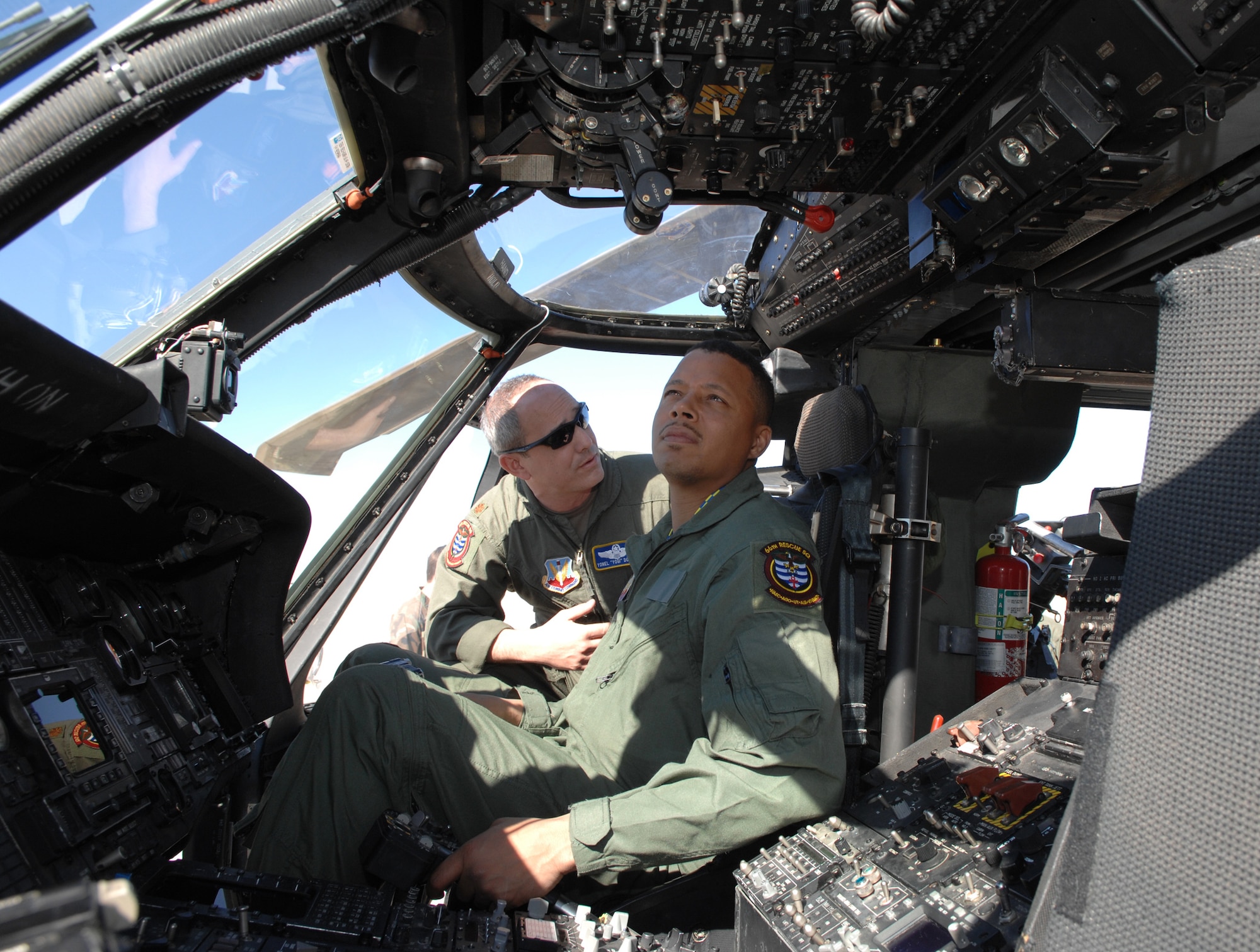 Maj. Yonel "Yogi" Dorelis, 66th Rescue Squadron pilot, briefs Oscar-nominated actor Terrence Howard on the HH-60G helicopter at Nellis Air Force Base, Nev. on March 16. Mr. Howard will be starring in  “Iron Man,” which begins filming soon. The U.S. Air Force will be depicted in a number of scenes in the film. (U.S. Air Force photo by Tech. Sgt. Scottie McCord)
