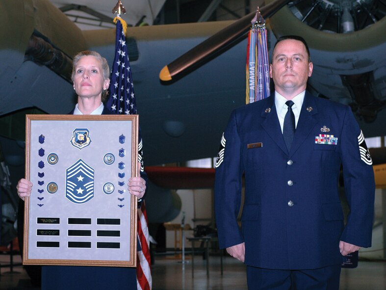 In a symbolic ceremony March 10 at the Air Mobility Command Museum, Chief Master Sgt. Caroline V. Vennell, 512th Airlift Wing command chief, passes on her command chief master sergeant responsibilites to the newly appointed command chief. Chief Master Sgt. William T. Wild III becomes the 512th AW's third command chief. The wing is a unit in the Air Force Reserve Command. (U.S. Air Force photo/1st Lt. Marnee A.C. Losurdo)