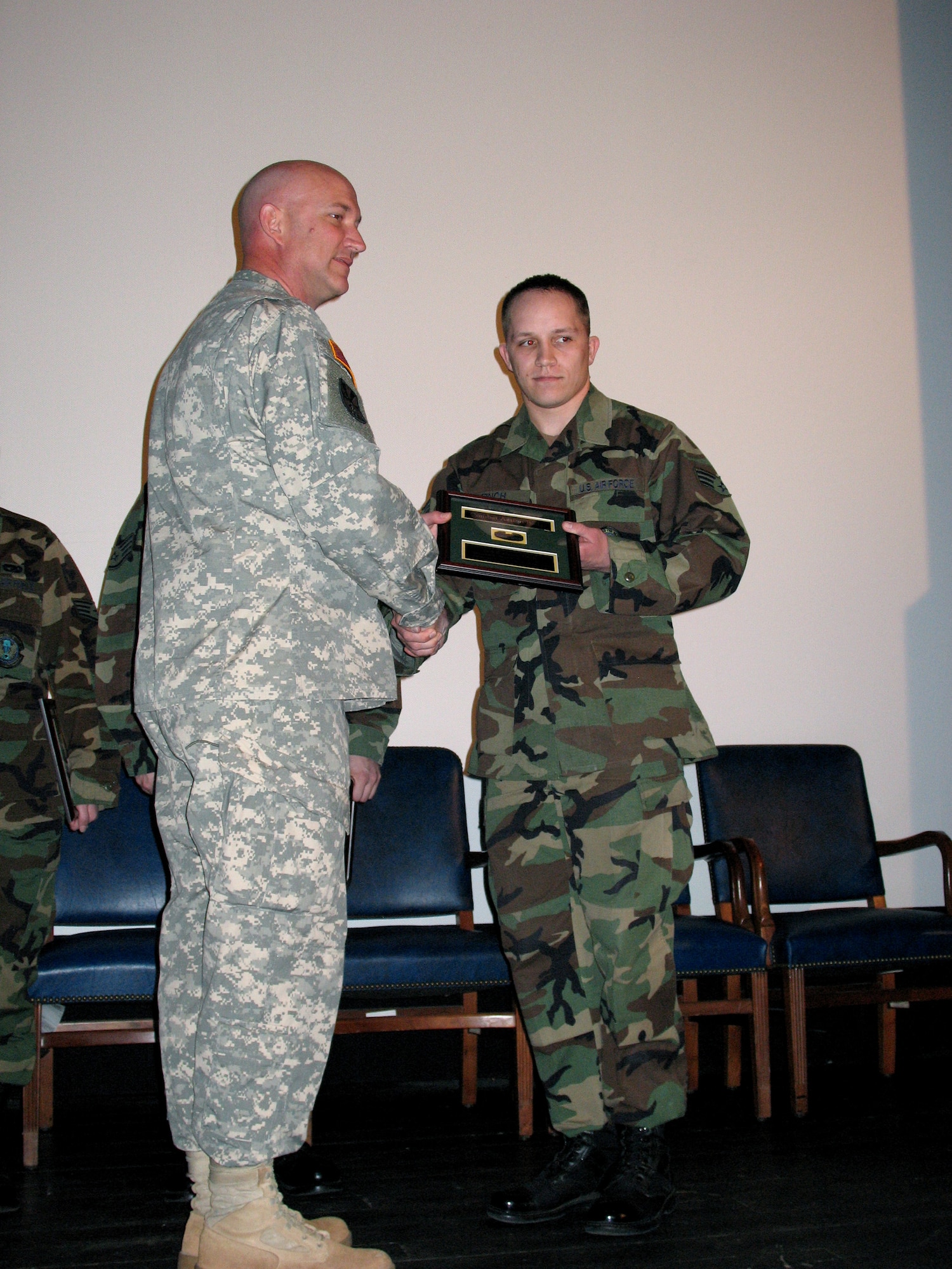 Army Colonel Michael MacNeil presents the Army Combat Action Badge to Senior Airman Benjamin Finch at Ramstein Air Base, Germany March 16. Airman Finch received the badge for his deployment to Iraq in support of the Army. He and four other Airmen were actively engaged in combat and Airman Finch's convoy was struck by an improvised explosive device. Colonel MacNeil was the commander of the 37th Transportation Command at the time. Airman Finch is a vehicle operations dispatcher assigned to the 435th Vehicle Readiness Squadron. (U.S. Air Force photo/ Staff Sgt. Jason David) 
