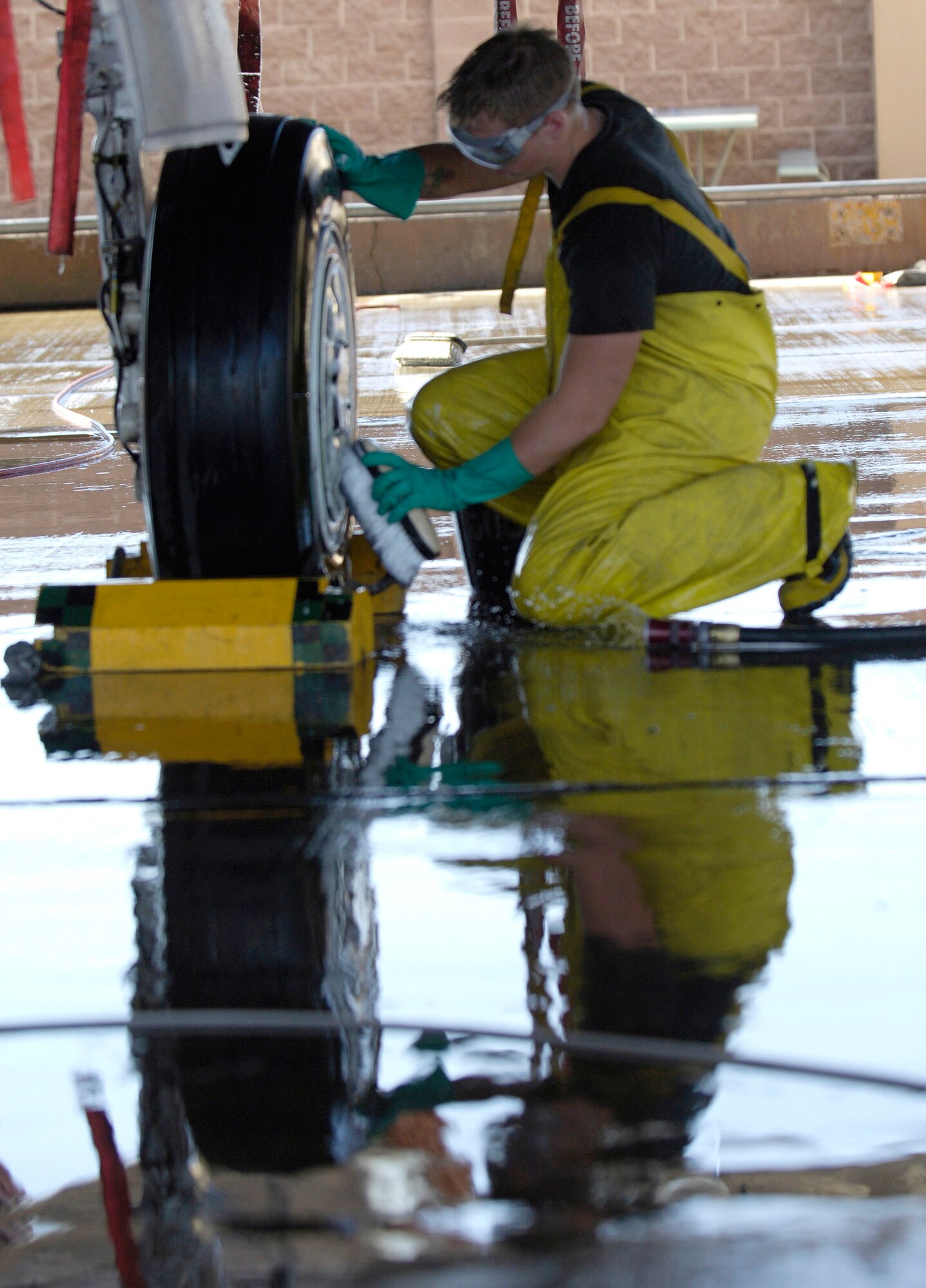 Airman 1st Class Dylan Edson scrubs the wheel of an F-15E Strike Eagle during a 120-day periodic cleaning March 15 at Nellis Air Force Base, Nev.  The complete F-15 cleaning process takes approximately four hours with a crew of three.  Airman Edson is an avionics specialist assigned to the 57th Aircraft Maintenance Squadron at Nellis.  (U.S. Air Force photo/Master Sgt. Kevin J. Gruenwald)