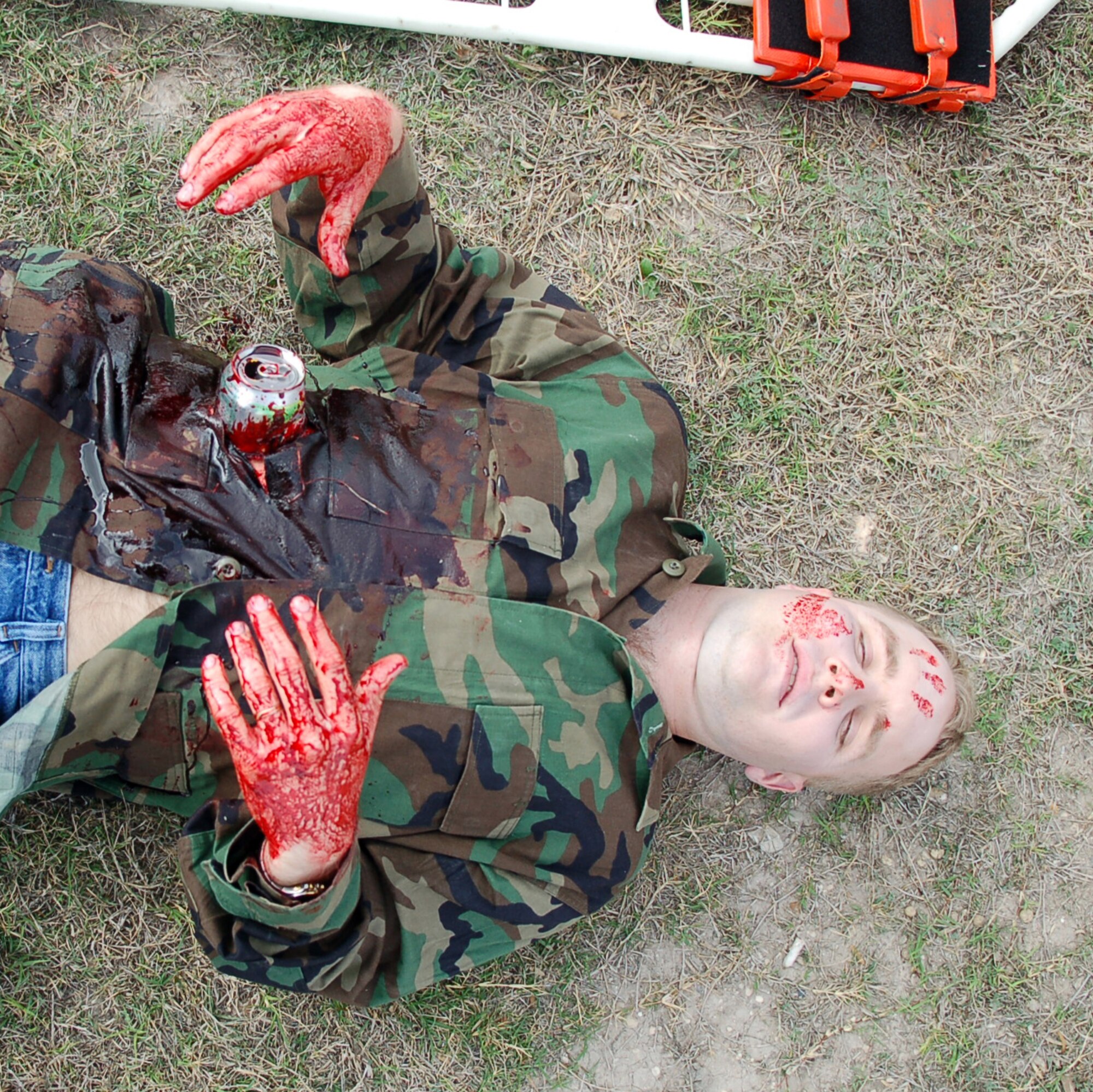 LAUGHLIN AIR FORCE BASE, Texas -- Sticky with simulated blood, a soda can “protruding” from his belly, 2nd Lt. Todd Mickel lays helplessly awaiting medical attention during an exercise involving a simulated tornado touch down near Outdoor Recreation.  (U.S. Air Force photo by Staff Sgt. Austin M. May)