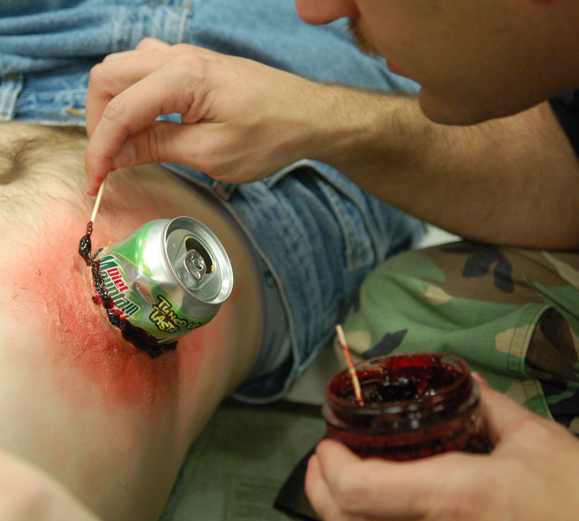 LAUGHLIN AIR FORCE BASE, Texas -- Capt. John Weaver, 47th Medical Group readiness officer, applies a jelly-type simulated blood to an injury involving a soda can embedded in a victim’s abdomen.  (U.S. Air Force photo by Staff Sgt. Austin M. May)