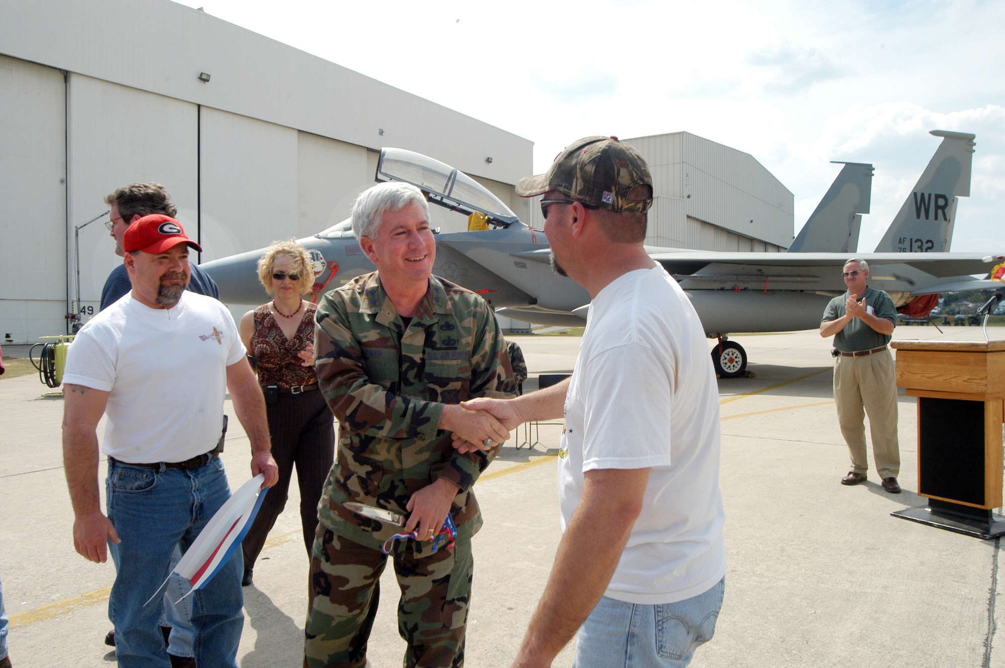 Maj. Gen. Tom Owen, Center commander, congratulates F-15 workers, Ricky McGlon, left, and Anthony Cross, on their new maintenance home. They, along with Walter Smith and Darian Fordham, helped the general cut the ribbon at a ceremony Tuesday. U.S. Air Force photo by Sue Sapp 