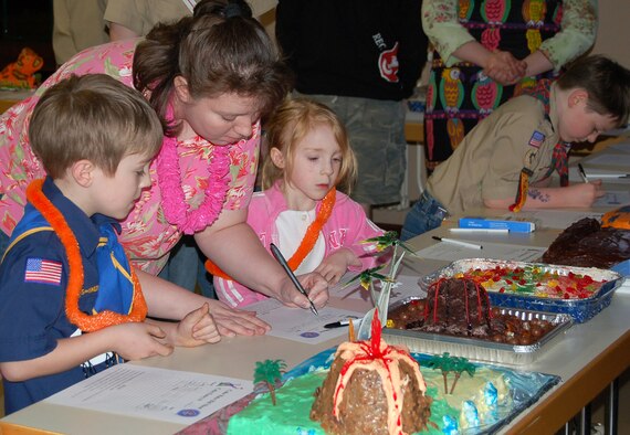 SPANGDAHLEM AIR BASE, GERMANY -- Tonya Elliot bids on a cake at the Boy Scouts of America Annual Blue and Gold Awards Banquet as her children Laura and Jonathan look on, Saturday. Mrs. Elliot is the wife of Staff Sgt. Mike Elliot, 52nd Operations Support Squadron. The cakes created by Boy Scouts and their fathers were sold to the highest bidder during the Boy Scouts of America Annual Awards Banquet. (US Air Force photo/Staff Sgt. Tammie Moore)