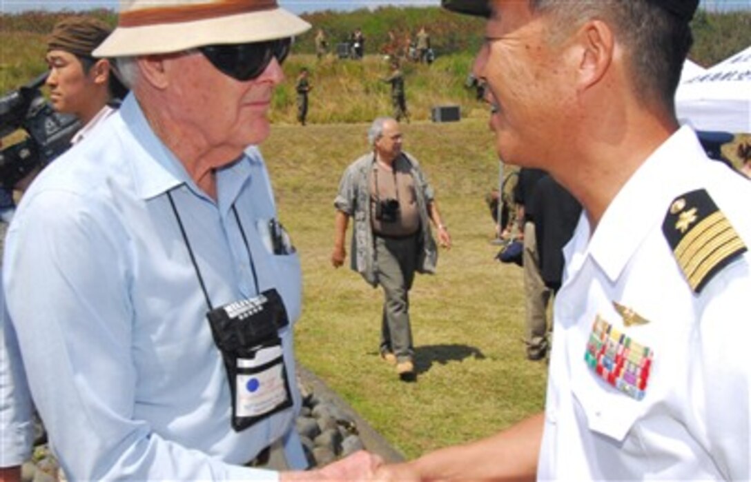 Japan Maritime Self Defense Force Capt. Tomonori Kudo, commander, Iwo Jima Airbase, shakes hands with a Battle of Iwo Jima survivor during a ceremony commemorating the 62nd anniversary of the Battle of Iwo Jima March 14, 2007, on Iwo Jima, Japan.