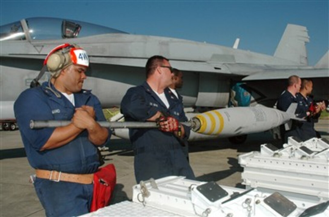 U.S. Navy sailors with ordnance departments of Strike Fighter Two Zero Four and Naval Air Station Joint Reserve Base New Orleans, ready bombs for attachment onto an F/A-18 Hornet aircraft during a training exercise at Naval Air Station Joint Reserve Base New Orleans, La., March 9, 2007.