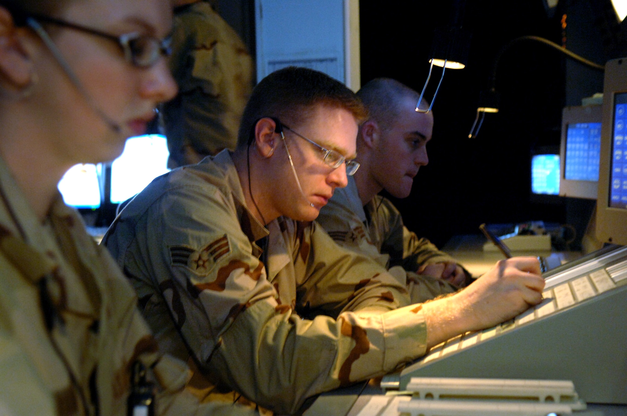 BALAD AIR BASE, Iraq - Senior Airmen Lacey Omara, Phillip Meseke, and Frank Gilman, 332nd Expeditionary Operations Support Squadron, air traffic controllers, work at the Combined Enroute Radar Approach Control (CERAP) facility here.  Airman Omara is working the Balad Center Scope position and Airman Meseke is performing the assist duties for the Scope position. Vital to the air traffic control team at Balad are the 38 air traffic controllers at the CERAP who work about 75,000 miles of Iraqi airspace. (U.S. Air Force photo/Staff Sgt. Michael R. Holzworth)