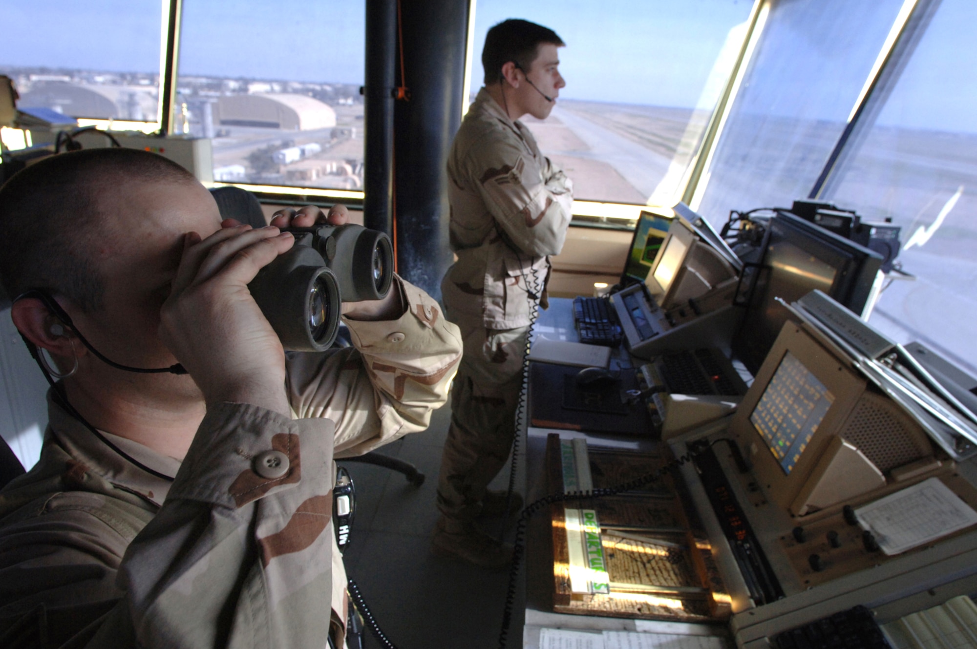 BALAD AIR BASE, Iraq - Senior Airman Mathew Hooke, and Airman 1st Class Eric Woodward, 332nd Expeditionary Operational Support Squadron, Air Traffic Controllers use binoculars to locate an aircraft on the horizon Mar. 10, 2007.  Balad Air traffic controllers comunicate with aircraft to ensure safe landings and takeoffs from the Balad tower. (U.S. Air Force photo/Staff Sgt. Michael R. Holzworth)