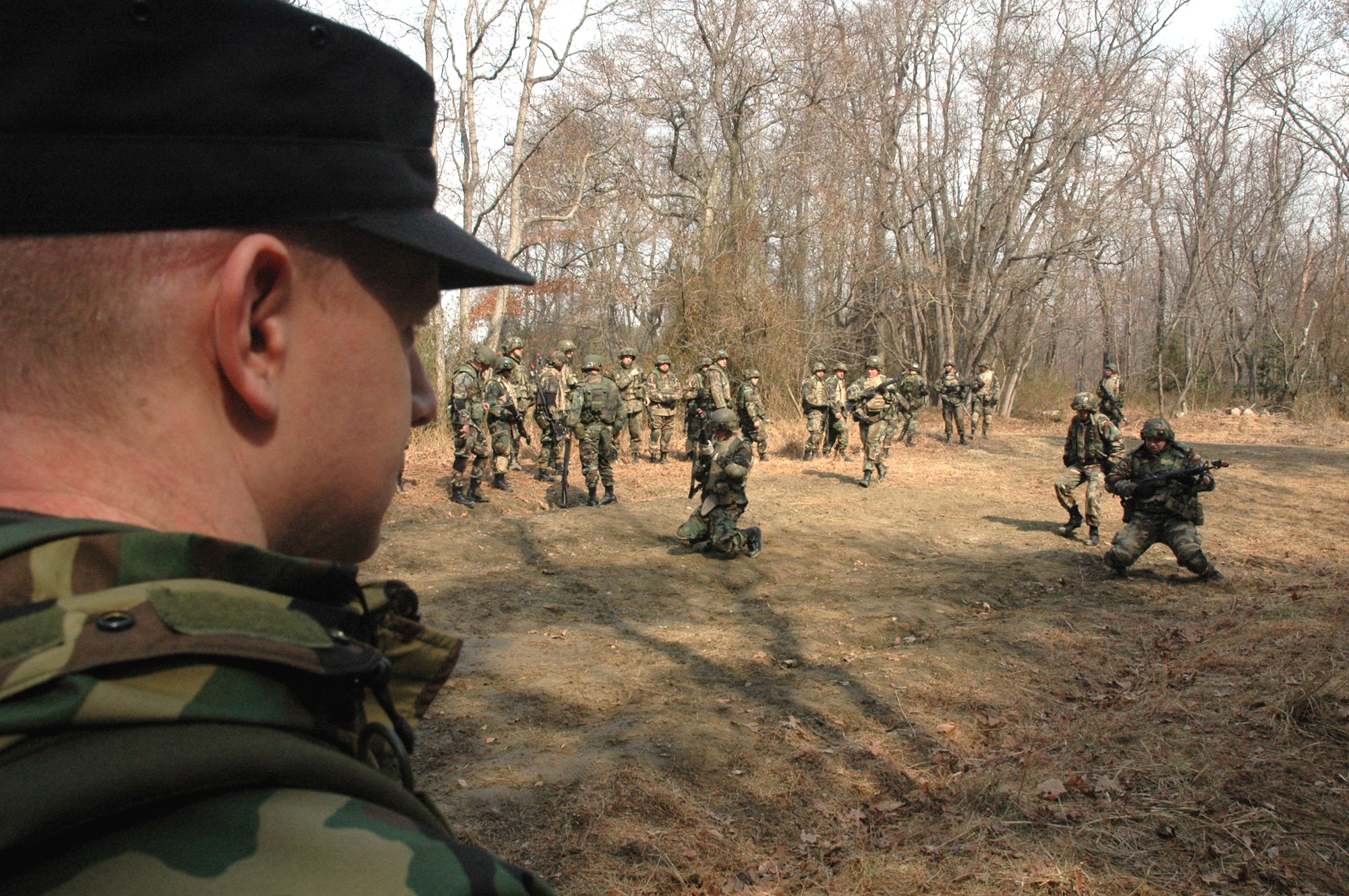 Staff Sgt. Wyatt Bloom, contingency skills training instructor, observes as Airmen practice squad and fire team manuevers as part of a tactics and patrolling class for the Advanced Contingency Skills Training Course March 14 on a range on Fort Dix, N.J. The course, made up of more than 300 students, prepares Airmen for upcoming deployments through teaching areas such as deployment tactics, patrolling, convoy operations and self defense. The course is taught by the U.S. Air Force Expeditionary Center's 421st Combat Training Squadron. (U.S. Air Force photo/Tech. Sgt. Scott T. Sturkol)

