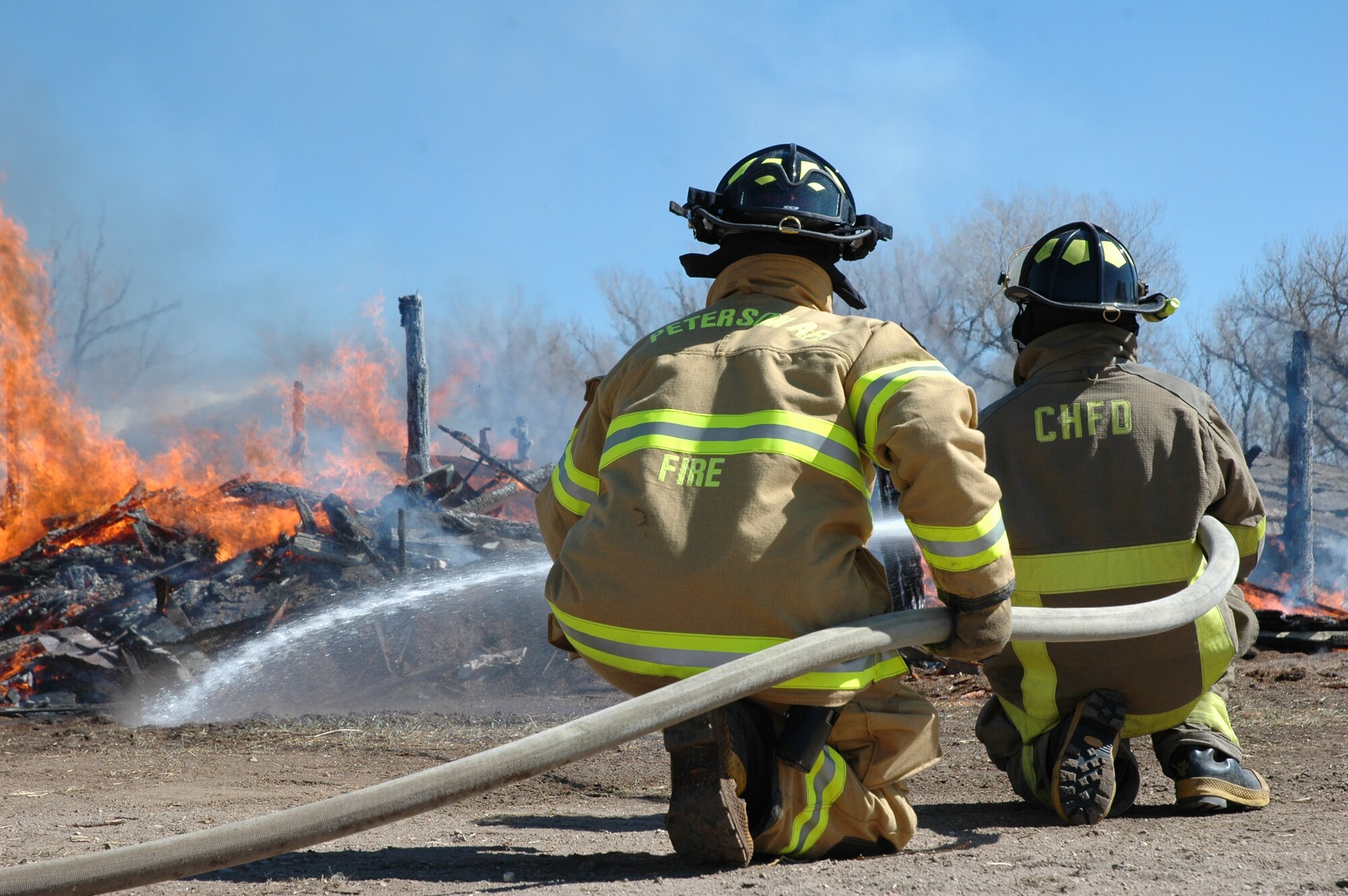 Members of the Peterson Air Force Base and Cimarron Hills fire departments team up during a joint training exercise March 19 at the Banning-Lewis Ranch. The joint training exercise also included members from the Colorado Springs, Falcon and Westcott fire departments. (U.S. Air Force photo by Tech. Sgt. Matt Gilreath)