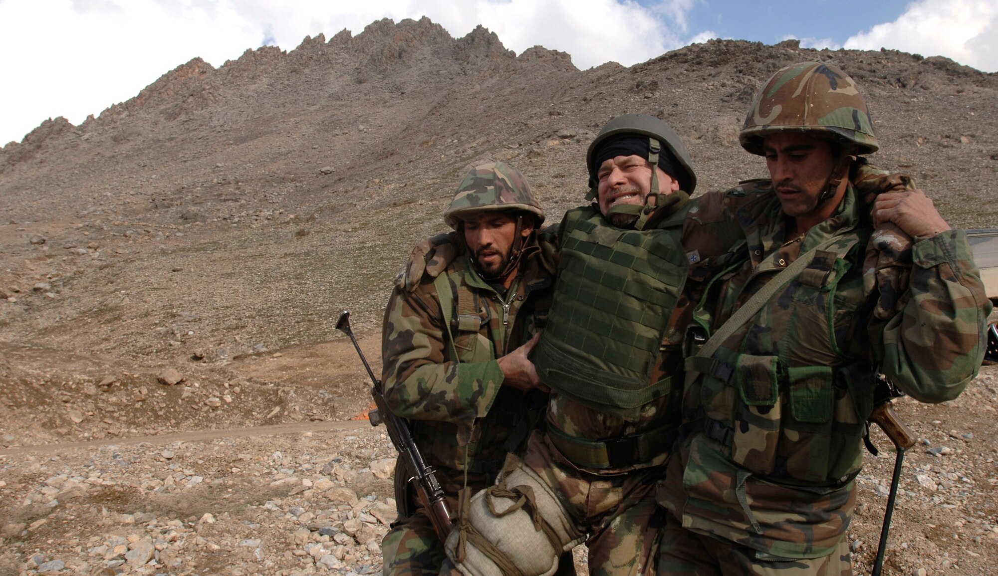 Two Afghan National Army officer candidates rush a "patient" to a waiting helicopter March 15 during a medical evacuation exercise being held at the Kabul Military Training Center in Afghanistan.  U.S. Air Force members provide military guidance and mentorship for the ANA instructors, officers and trainees at KMTC.  (U.S. Air Force photo/Tech. Sgt. Cecilio M. Ricardo Jr.) 