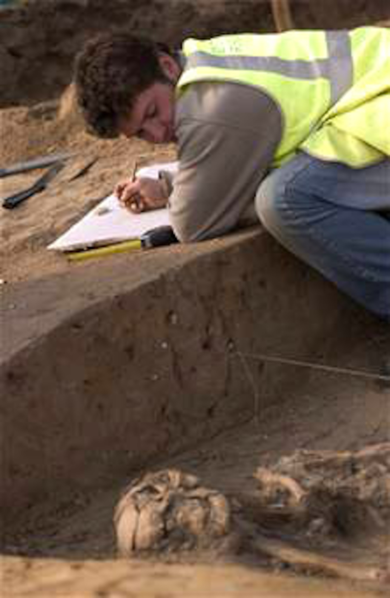 John Sims, an archeologist for Suffolk County Council, England, sketches a drawing March 14 of human remains prior to removing the bones from Royal Air Force Mildenhall, England. The skeleton was found during an excavation where new base housing is planned to be constructed. It was estimated on site to be of 1st Century A.D. Roman descent between 1,900 and 2,000 years old. (U.S. Air Force photo/Tech. Sgt. Tracy L. DeMarco) 