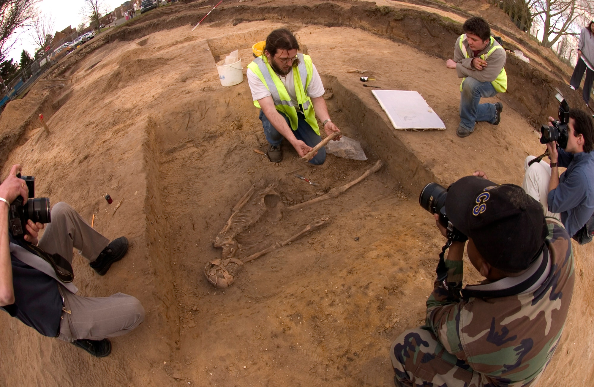 John Craven, an archeologist for Suffolk County Council, lifts the remains of a human skeleton from the earth March 14 at Royal Air Force Mildenhall, England. The skeleton was found during an excavation at Beck Row base housing where new construction is planned. The remains were estimated be of 1st century A.D. Roman descent between 1,900 and 2,000 years old. (U.S. Air Force photo/Tech. Sgt. Tracy L. DeMarco) 