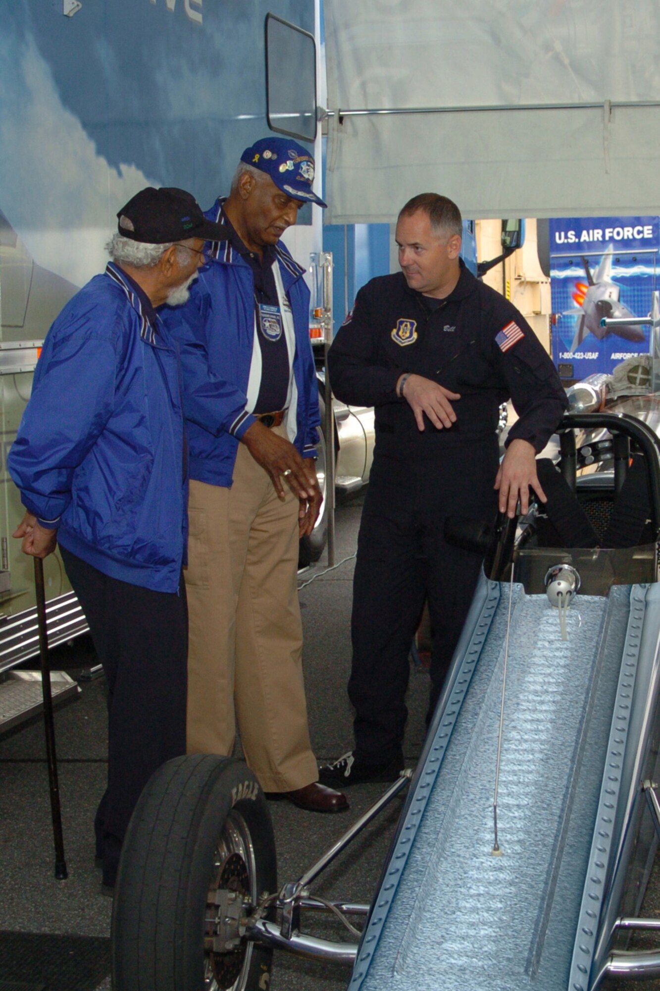 Air Force Reserve Jet Car driver, retired Master Sgt. Bill Braack discusses performance of the jet car with  Atlanta Chapter Tuskegee Airmen, retired Master Sgt. Val Archer and retired Chief Master Sgt. Donald Summerlin during JROTC Week at Dobbins ARB. 